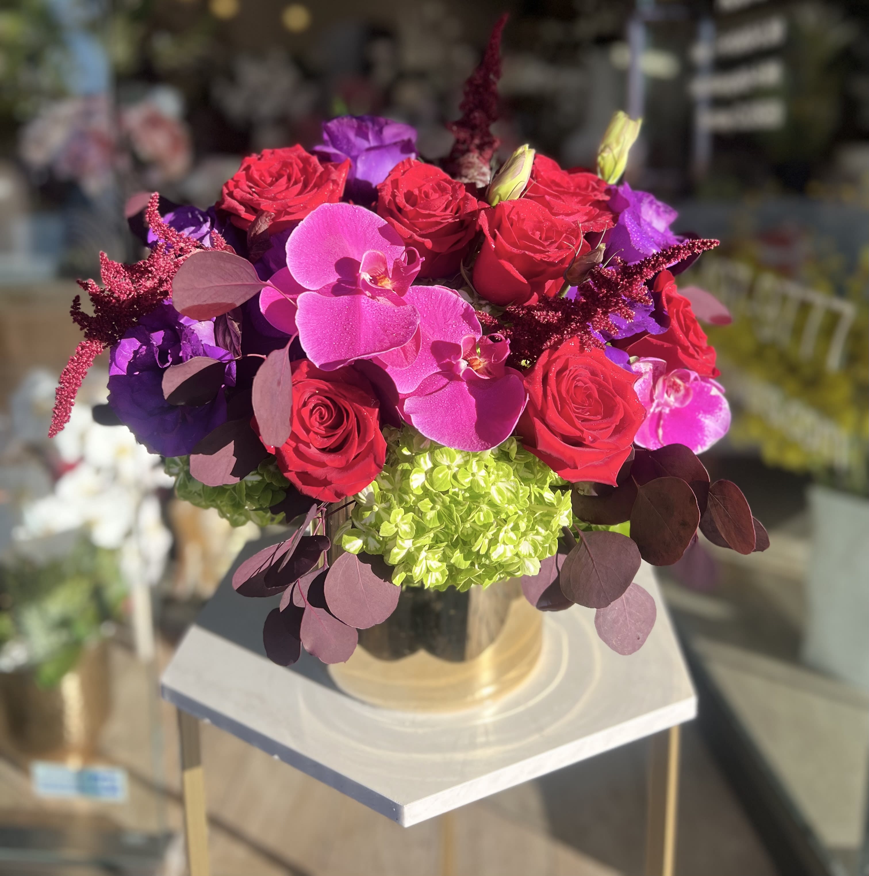 Bouquet of red roses and pink orchids in a glass vase