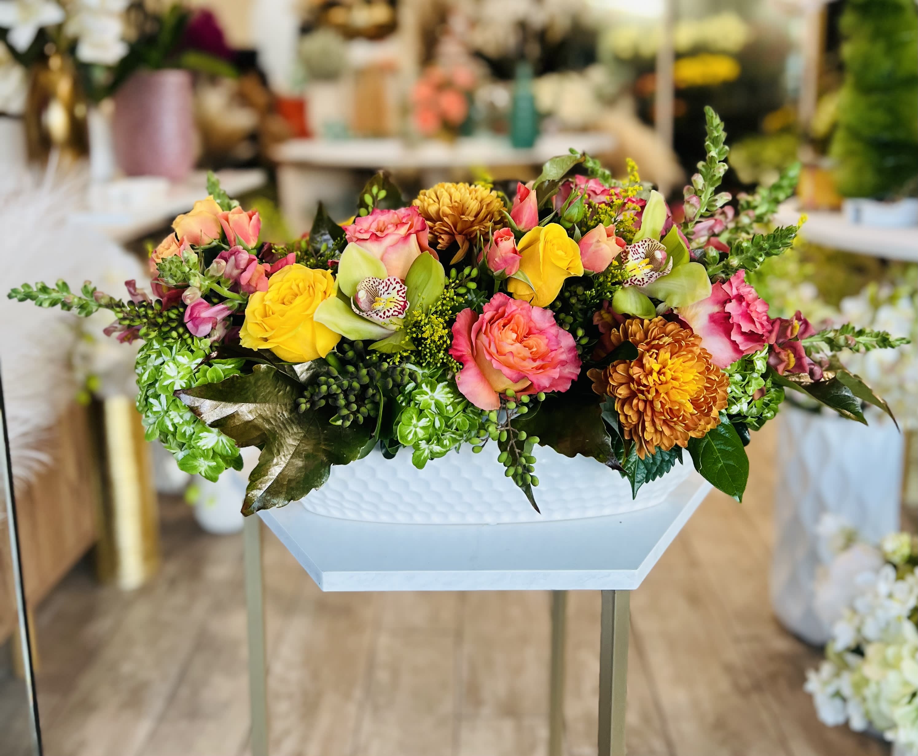 Colorful mixed flower arrangement in a white pedestal vase