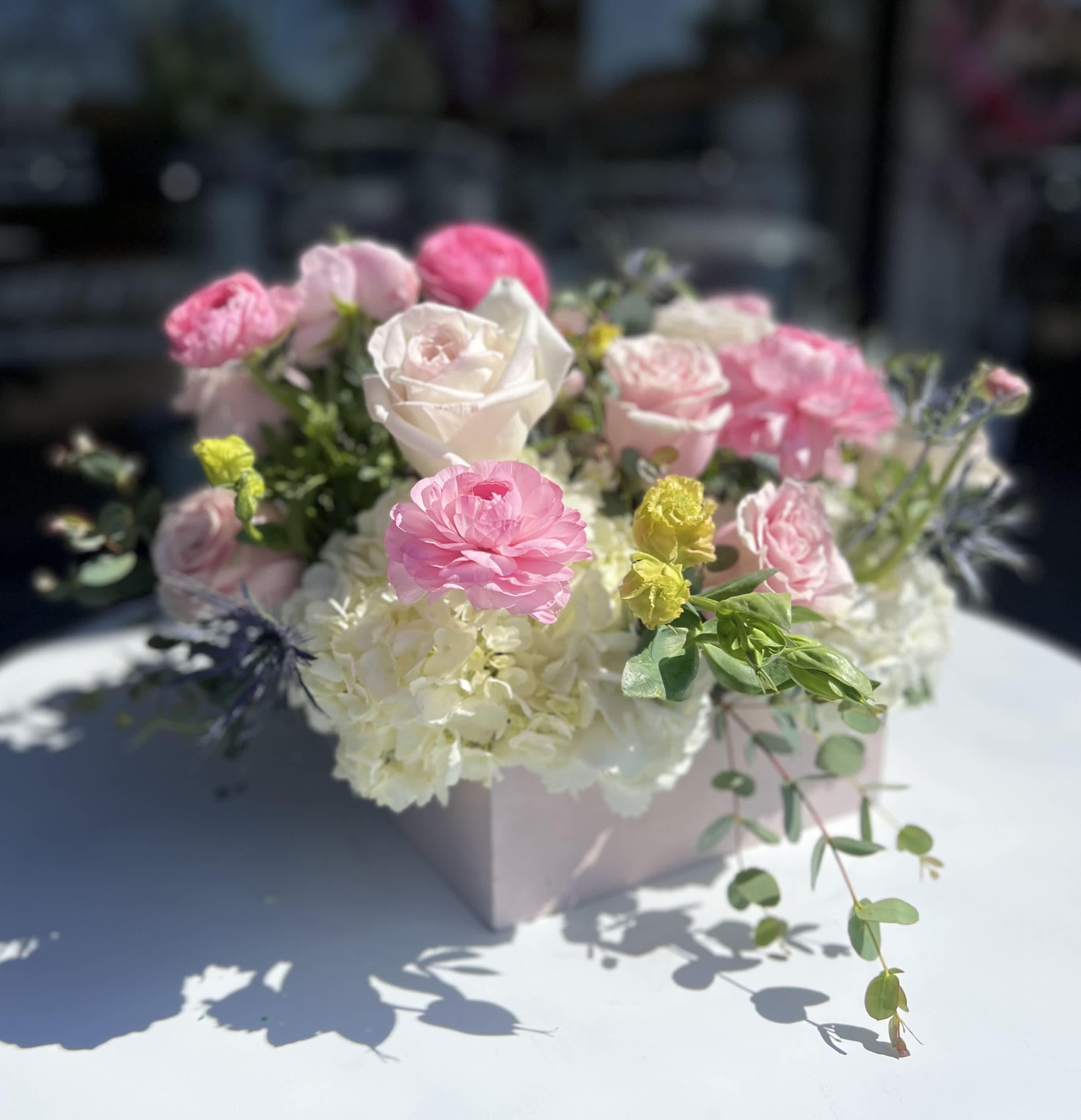 Pink and white roses with hydrangeas in a pale pink box