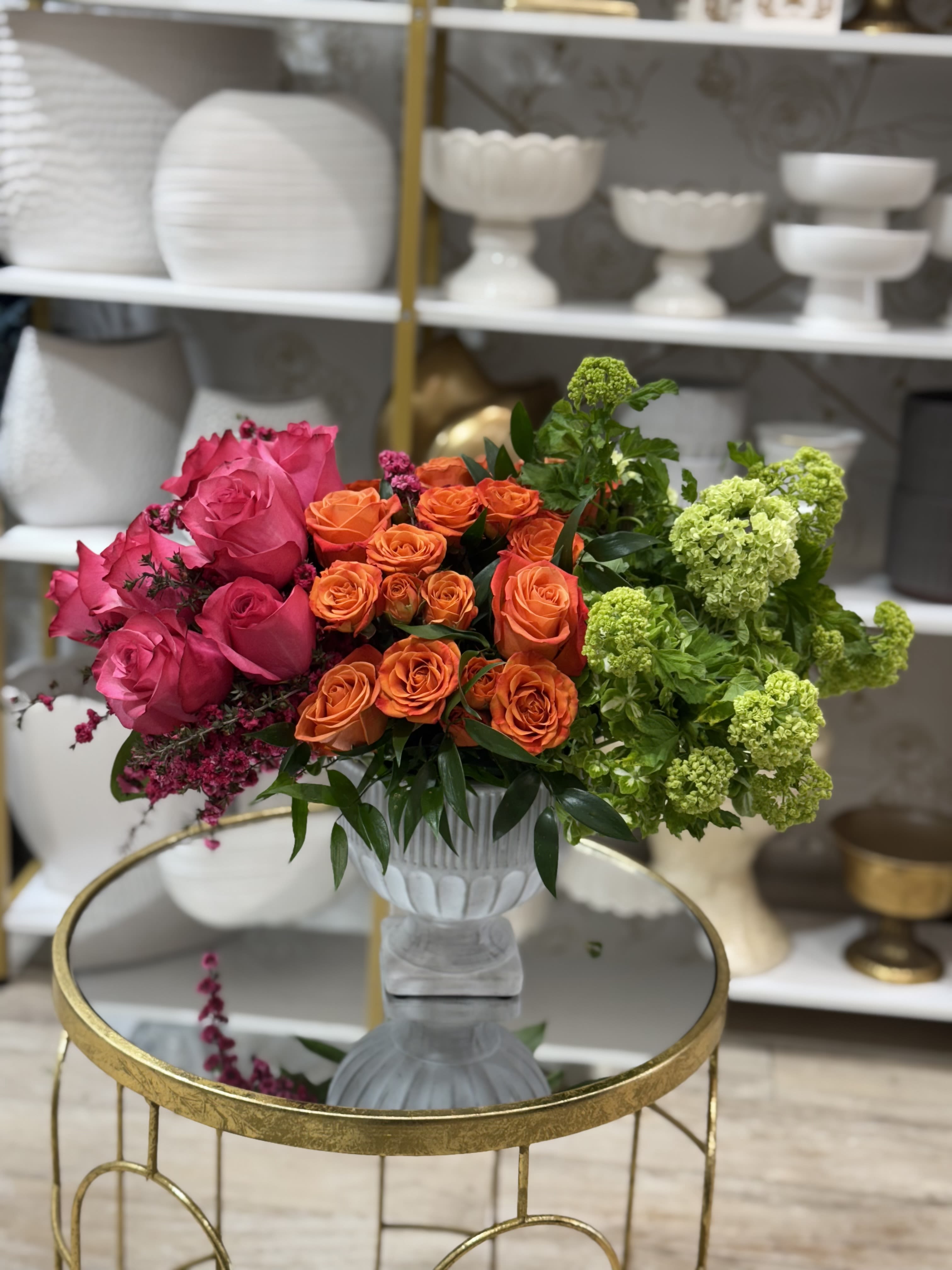 Bouquet of pink, orange, and green roses in a white vase