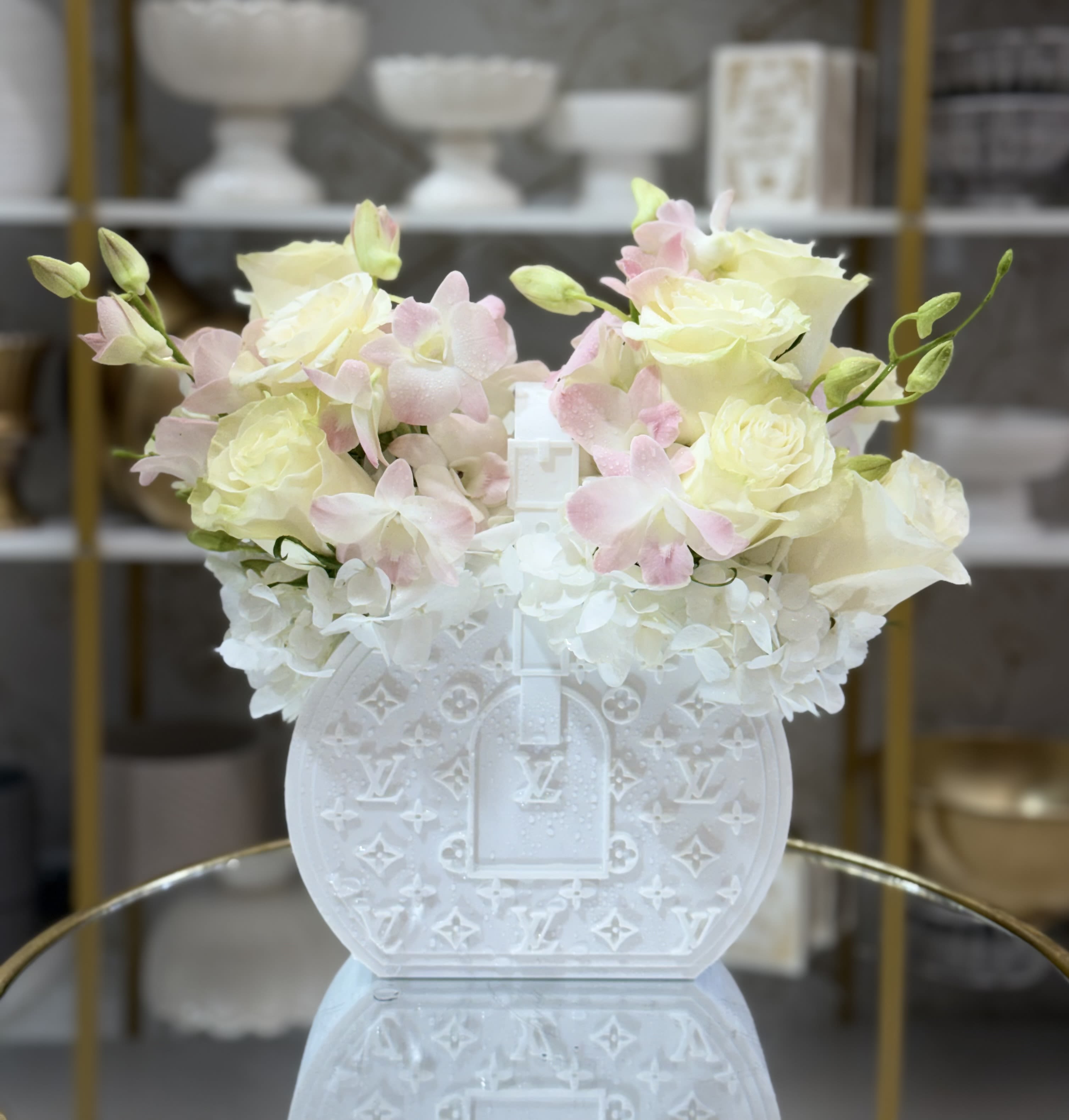 White floral arrangement in a decorative white handbag-shaped vase