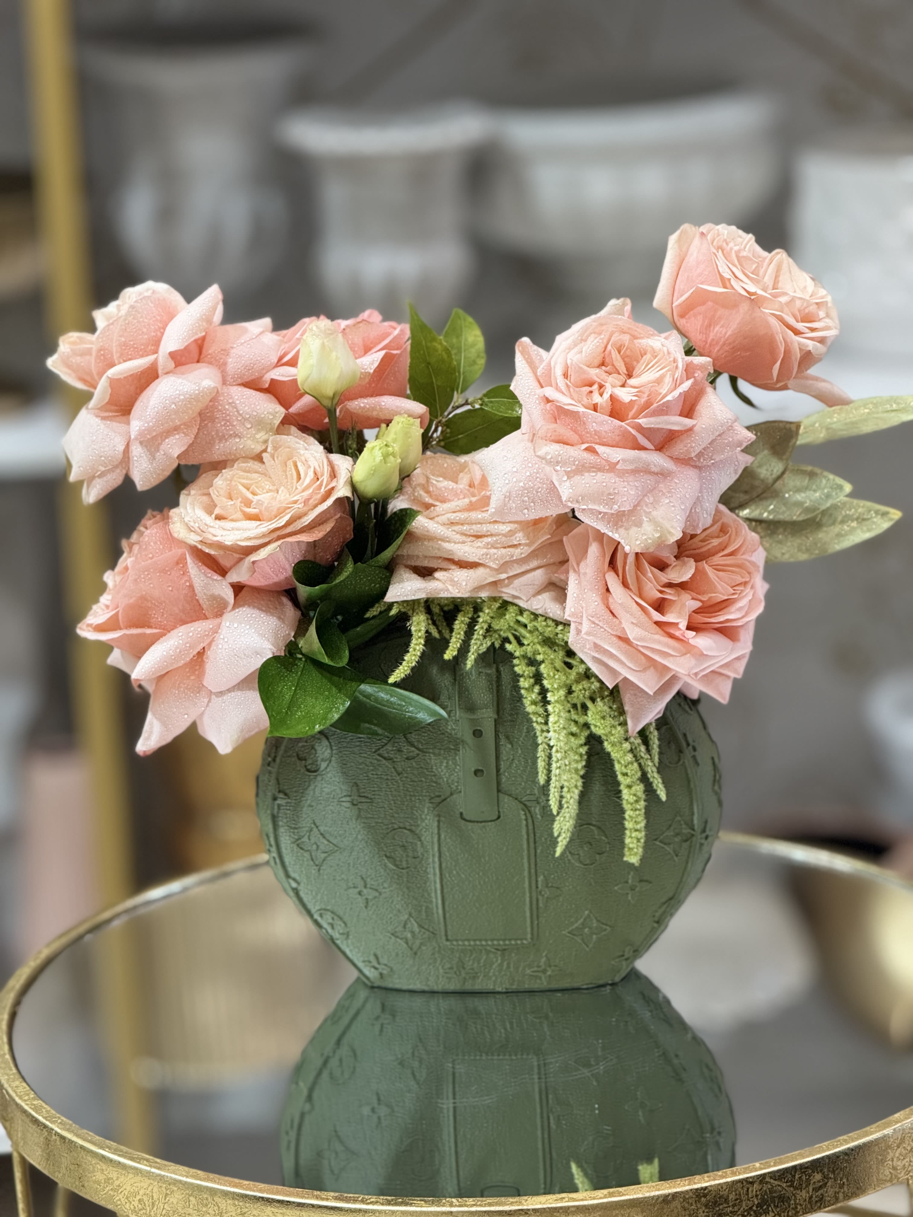 Pink roses arranged in a green patterned vase