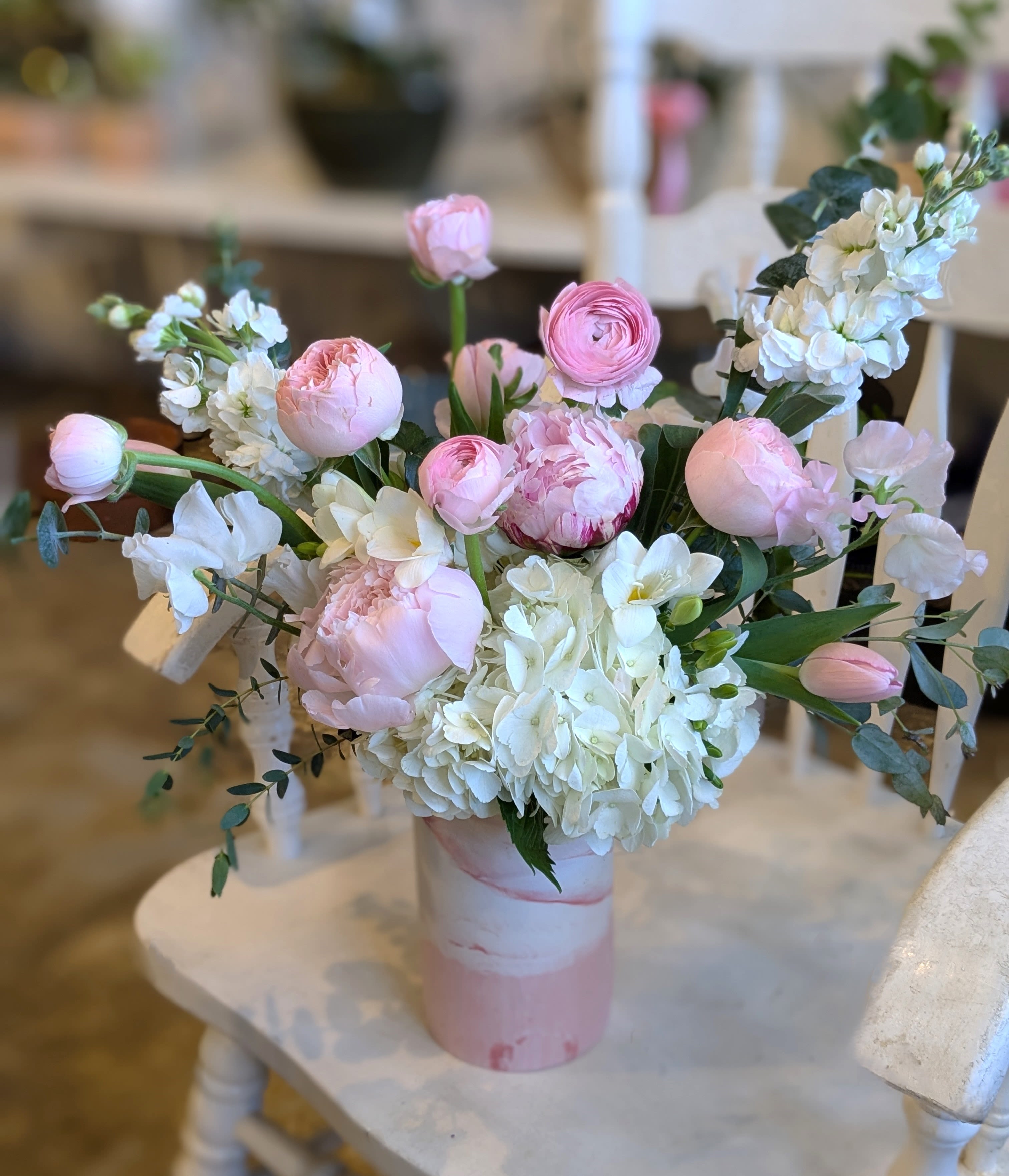 Pink and white floral arrangement in a pink vase