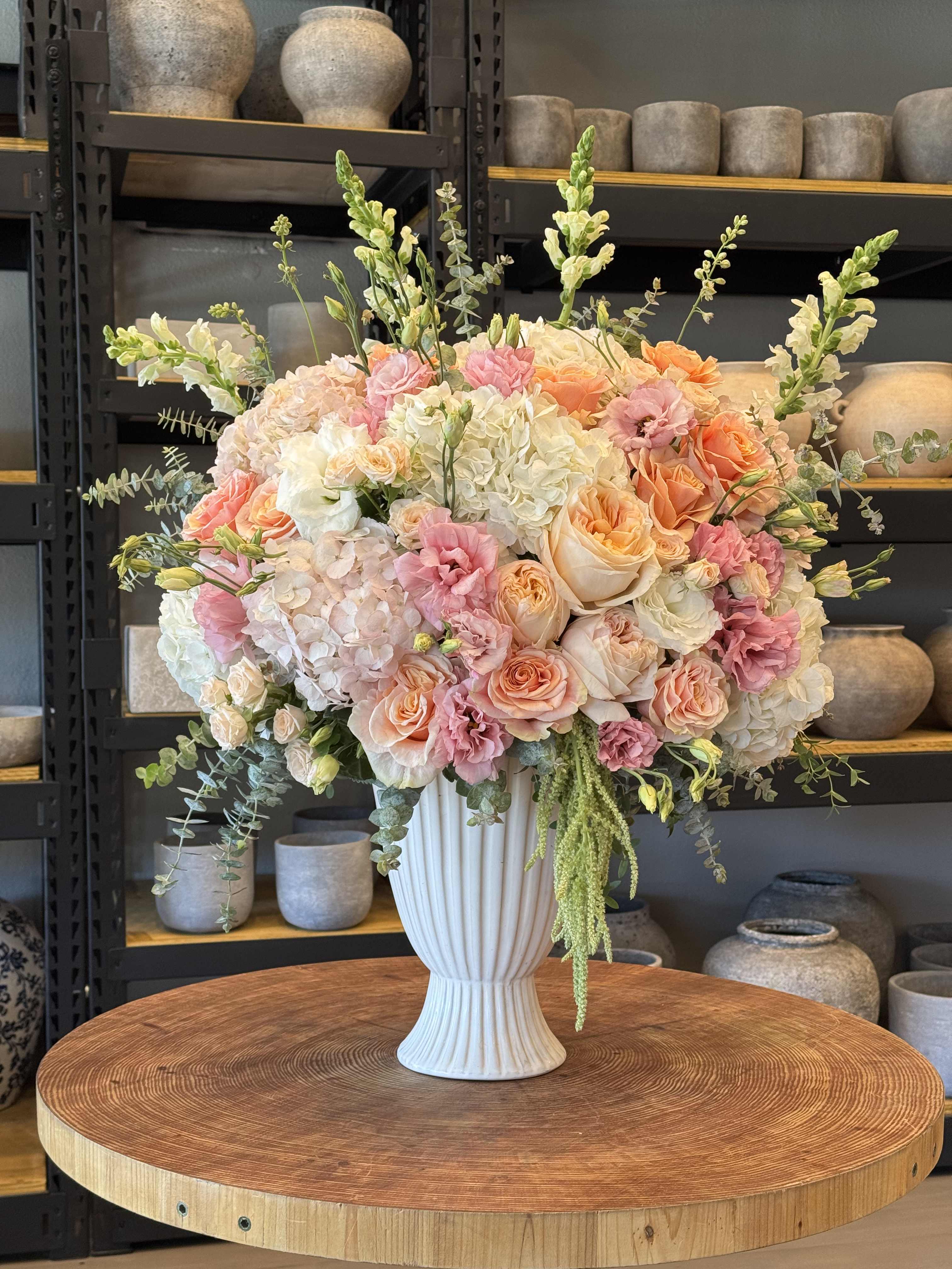 Large pastel flower arrangement in a white vase