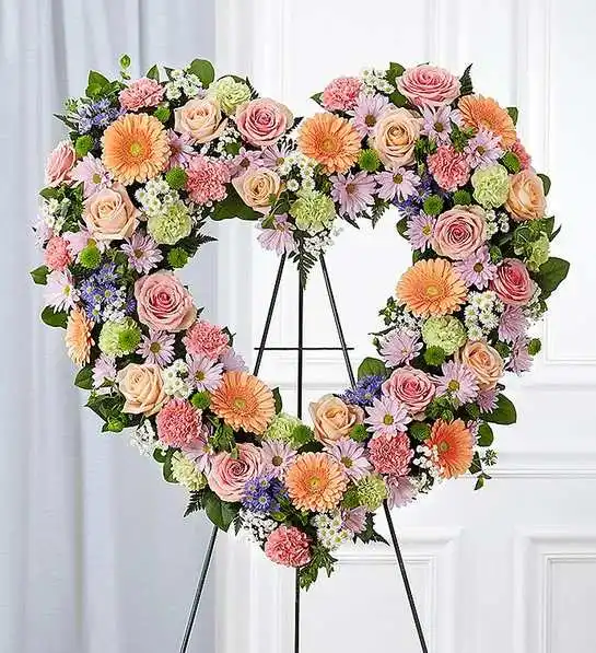 Always Remember  Floral Heart Tribute- Pastel - The warm and gentle love they showed to those around them will keep them always remembered. This sentiment is best captured with our standing, open heart-shaped arrangement in pastel hues. Handcrafted by our caring florists with an assortment of soft, pastel blooms, it is a magnificent tribute fitting for the funeral services.