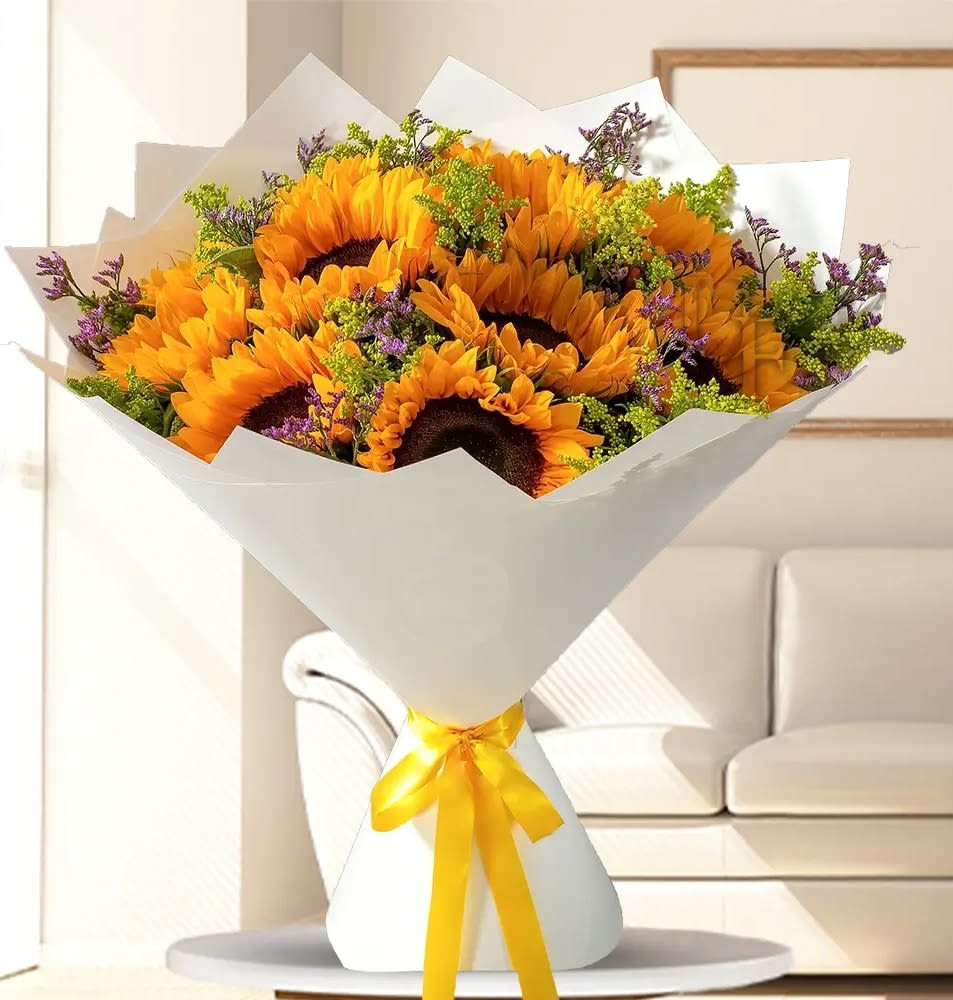 Bouquet of sunflowers wrapped in white paper with a yellow ribbon