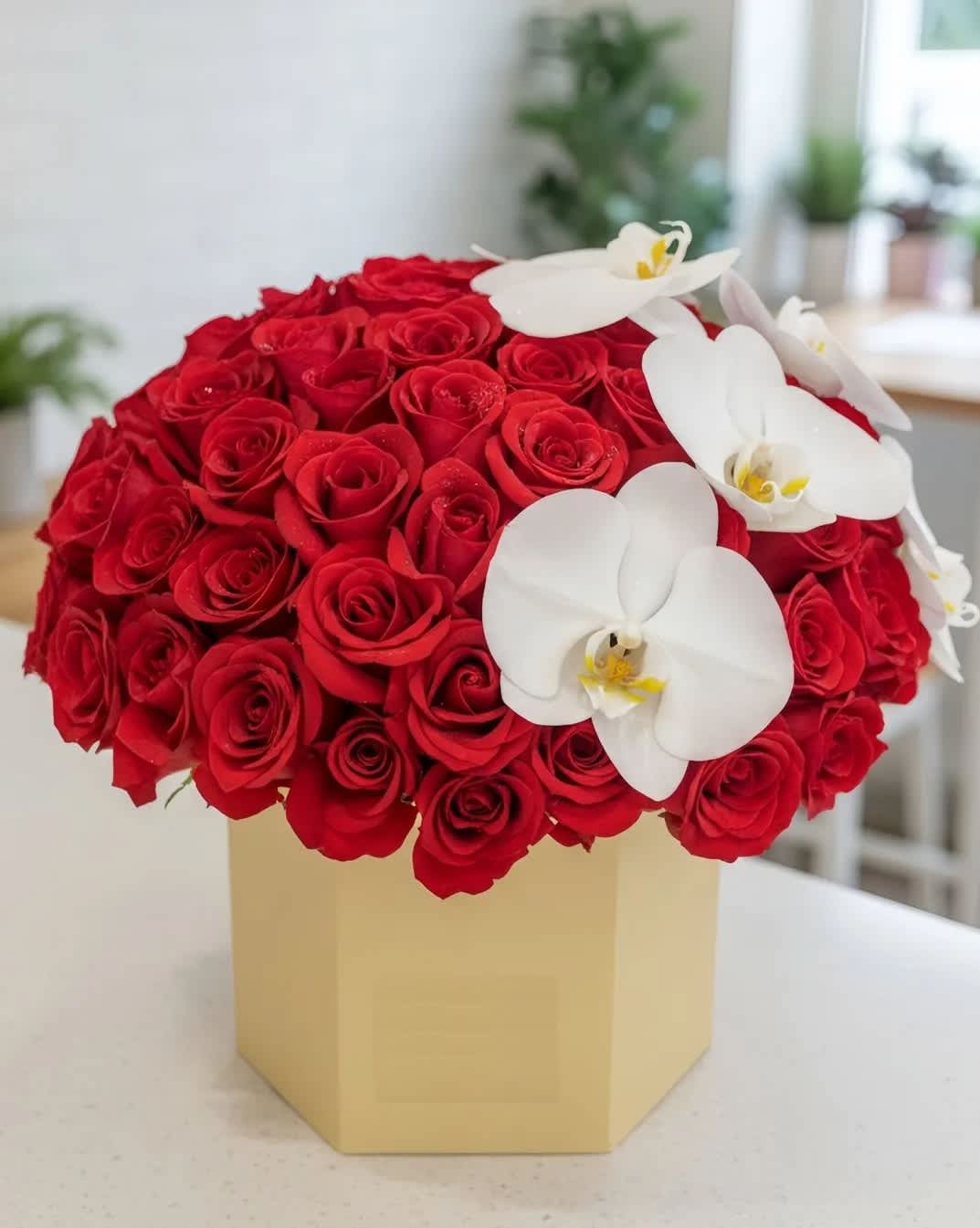 Red rose arrangement with white orchids in a beige box