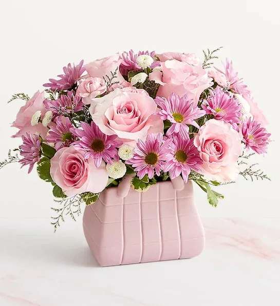 Pink roses and daisies arranged in a pink vase