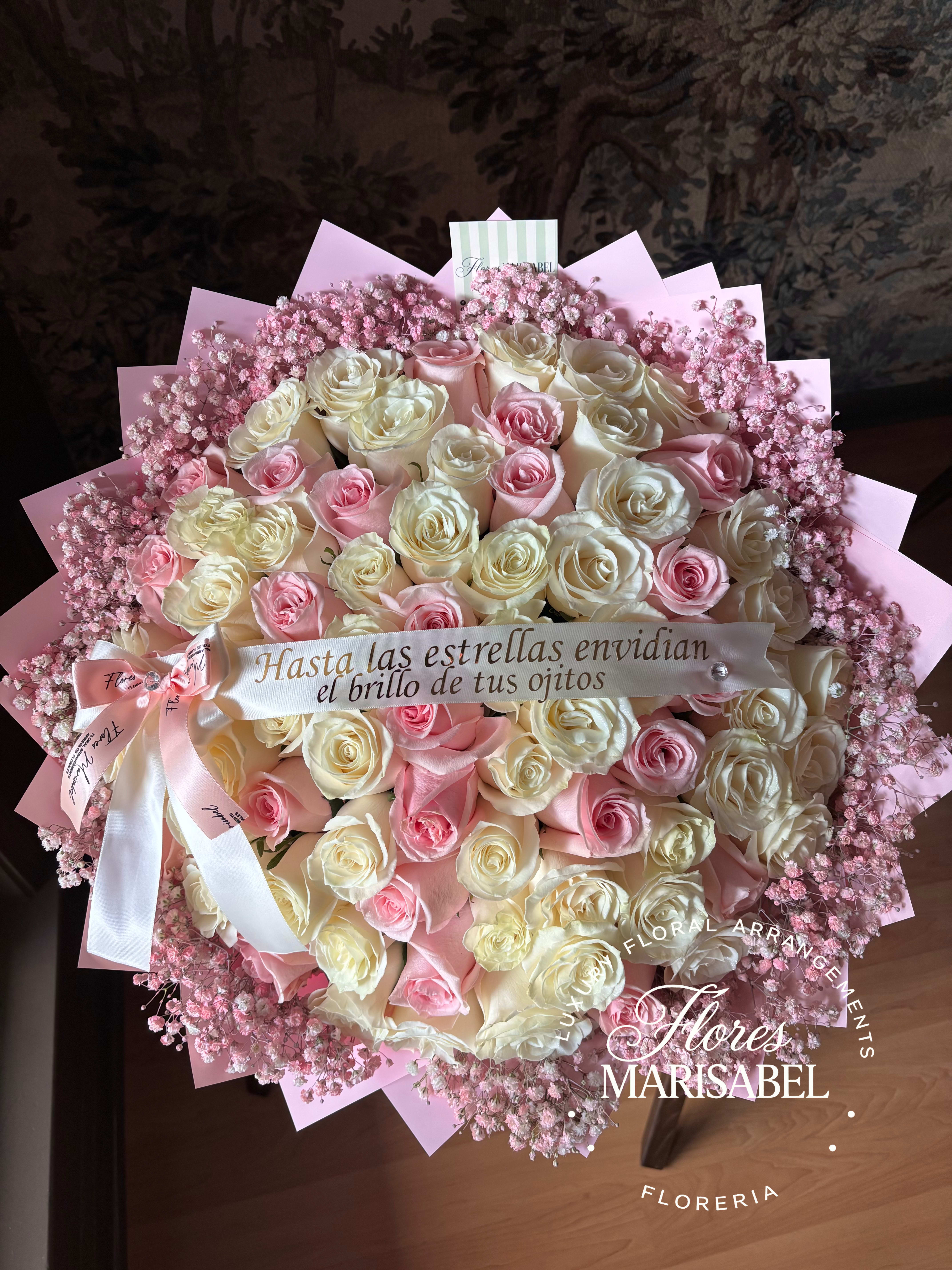Large bouquet of pink and cream roses with pink baby's breath and a ribbon