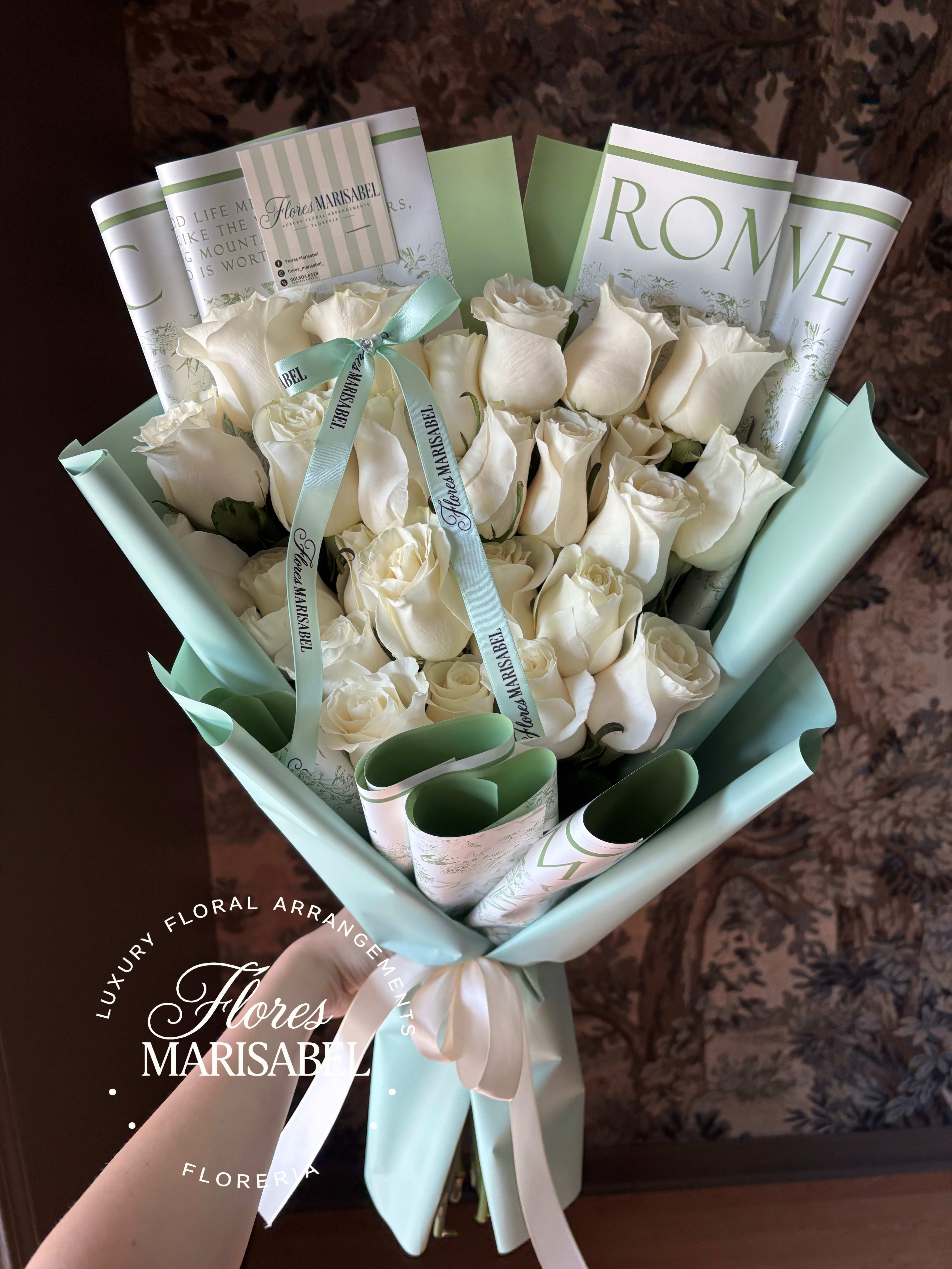 Bouquet of white roses wrapped in pale blue paper with ribbon