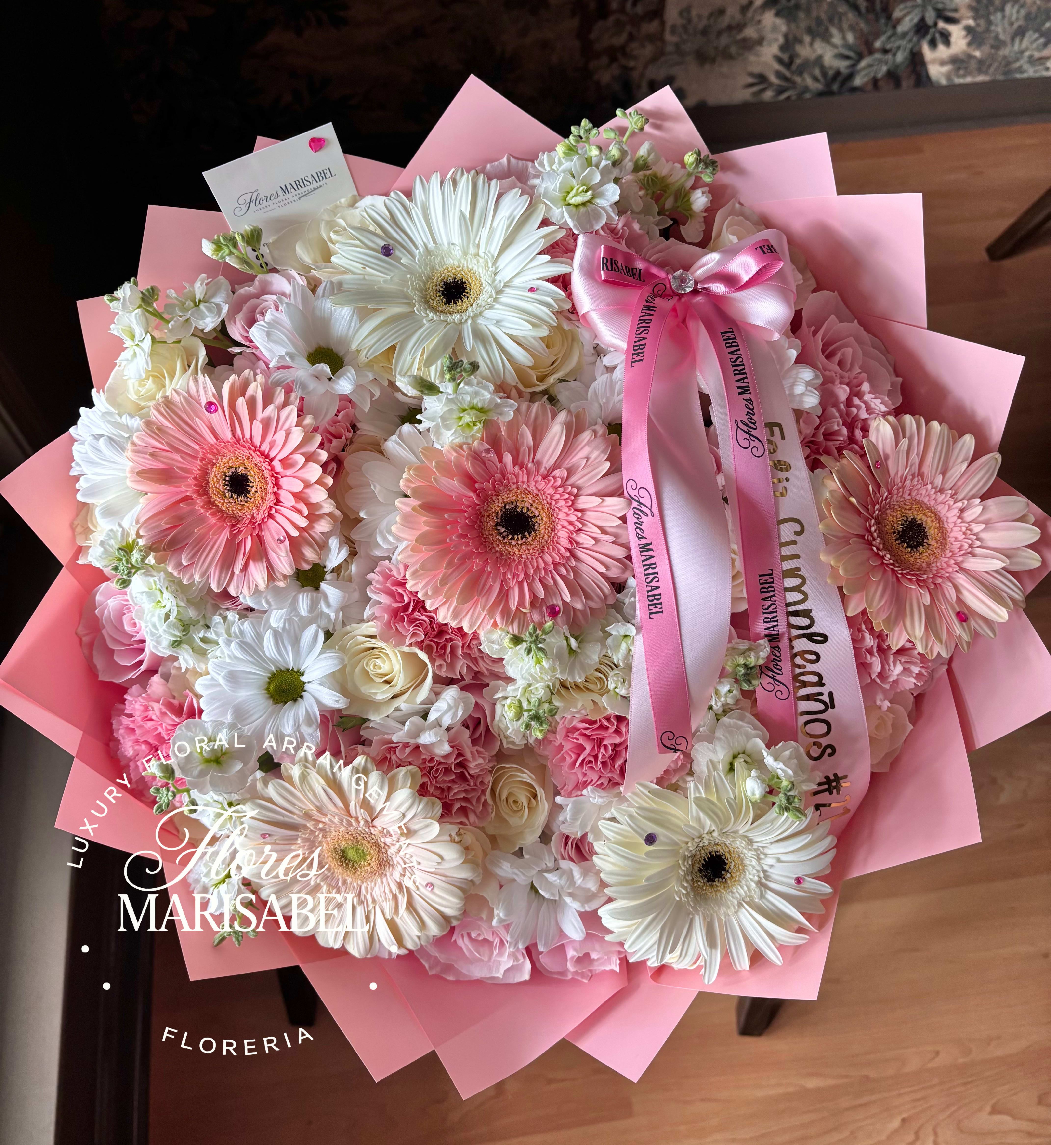Pink and white bouquet with gerbera daisies and roses wrapped in pink paper