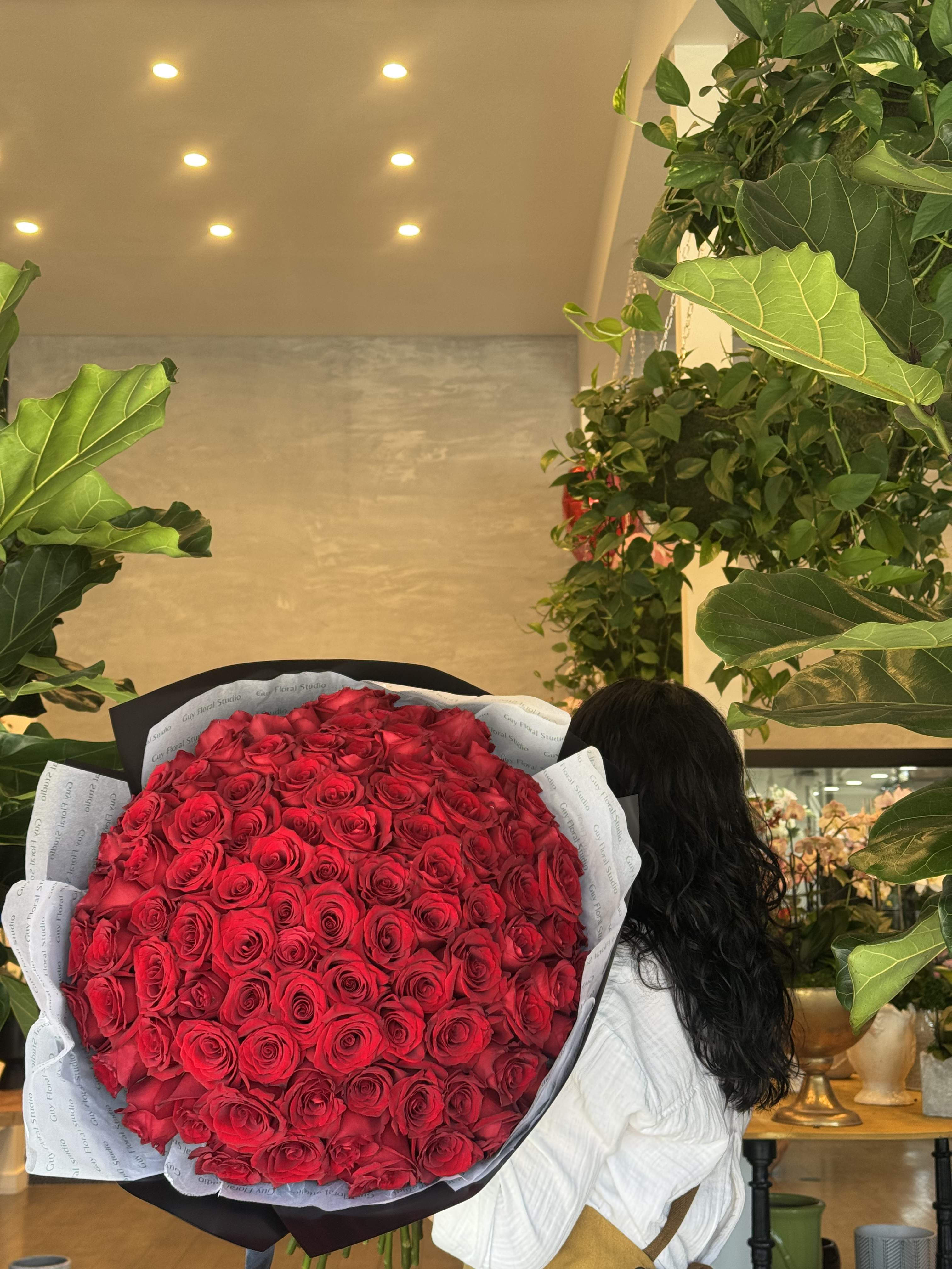 Large bouquet of red roses wrapped in black and white paper