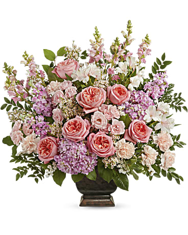 Pink roses and mixed pastel flowers arranged in a dark vase
