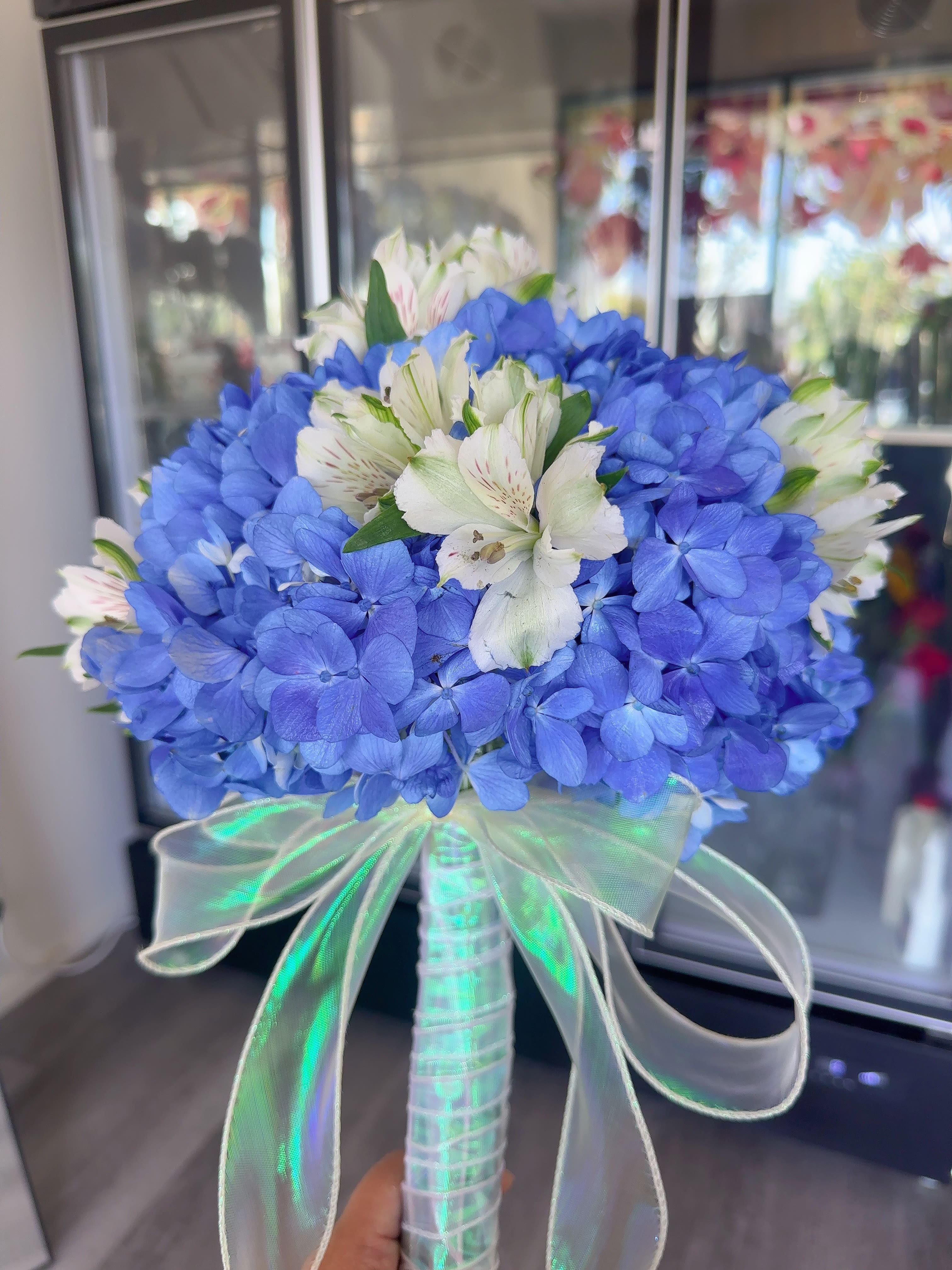 Blue hydrangea bouquet with white alstroemeria and a sheer ribbon handle