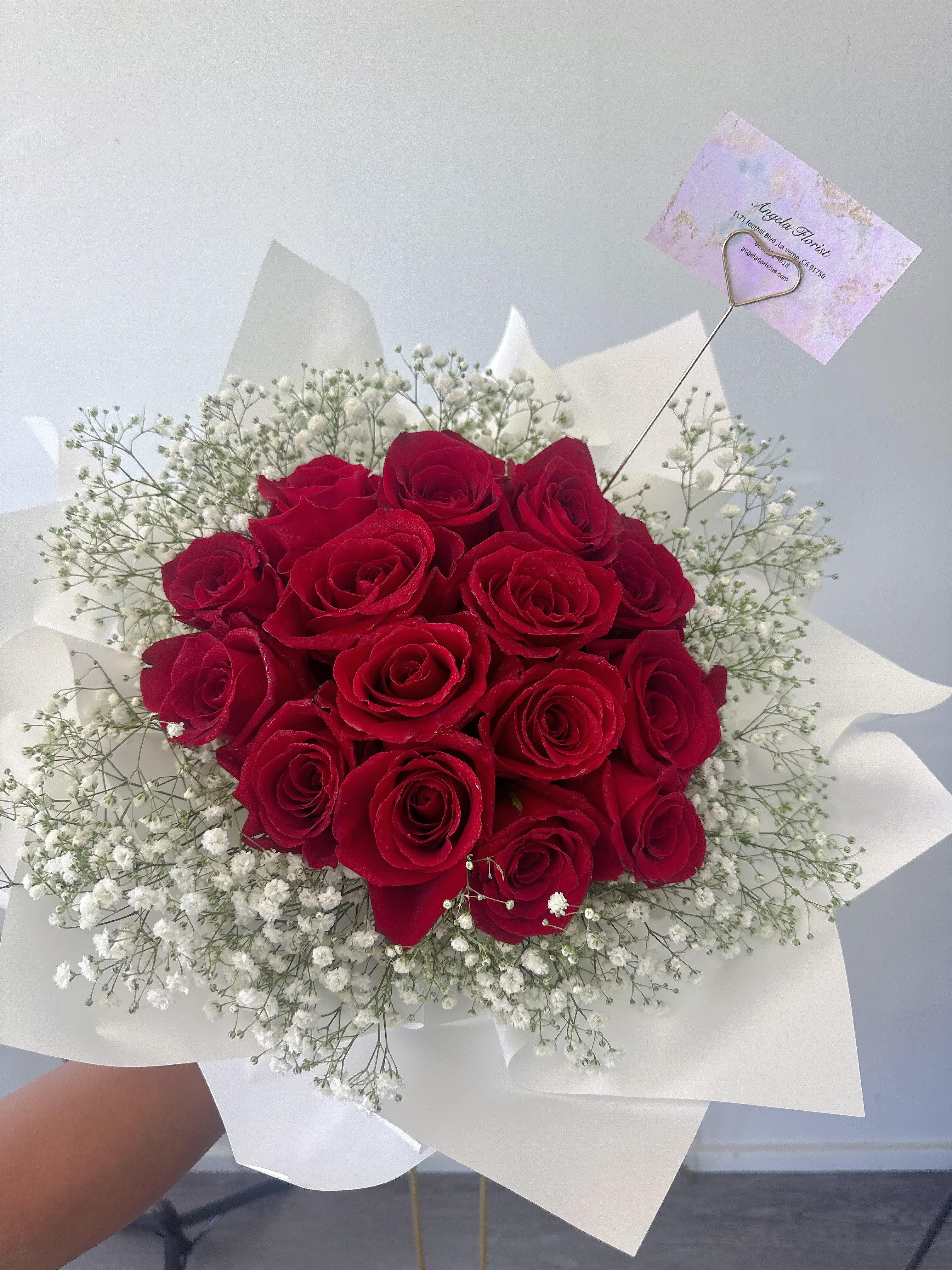 Bouquet of red roses with white baby's breath in white wrap