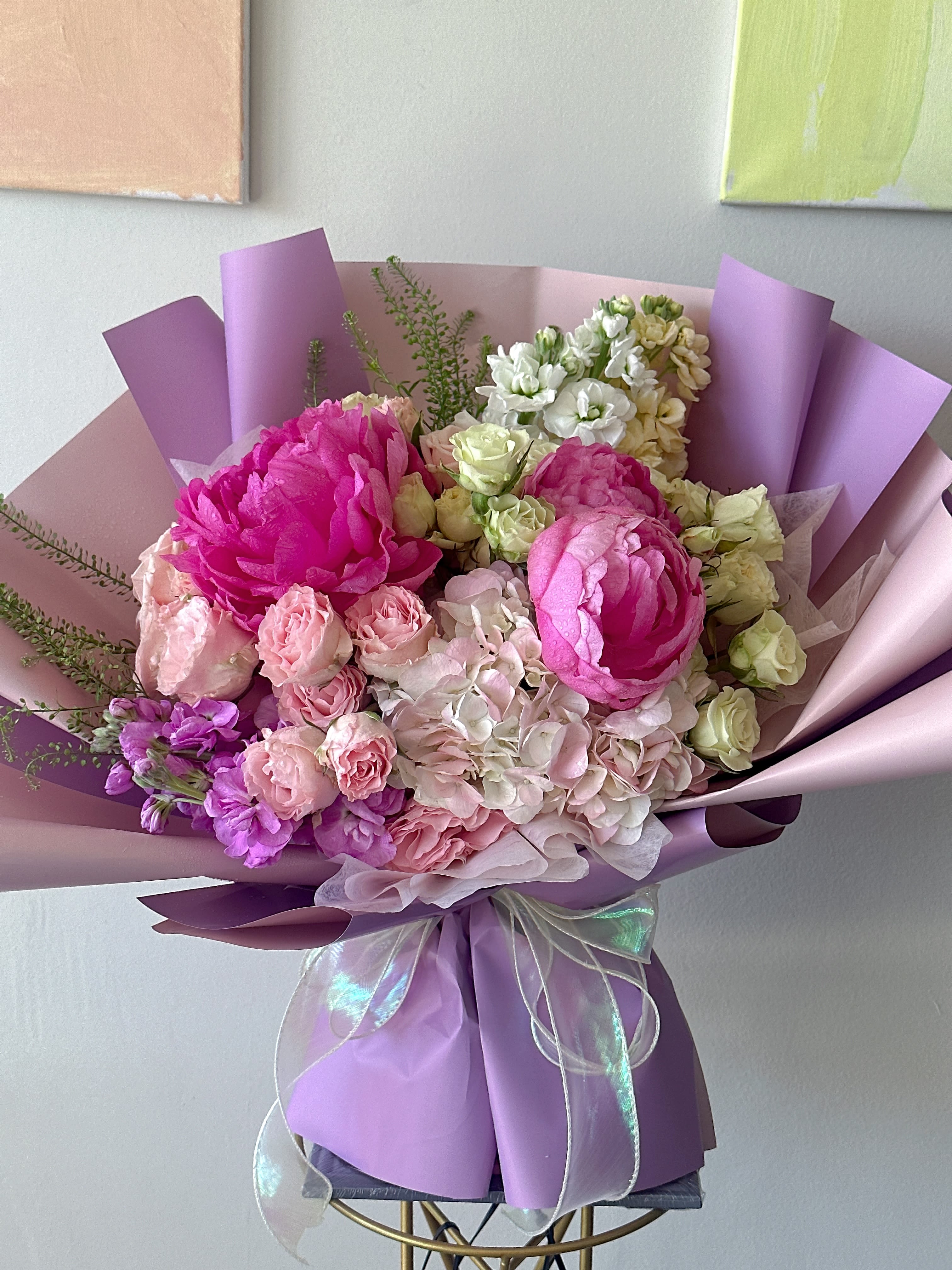 Bouquet of pink and white flowers wrapped in lavender paper