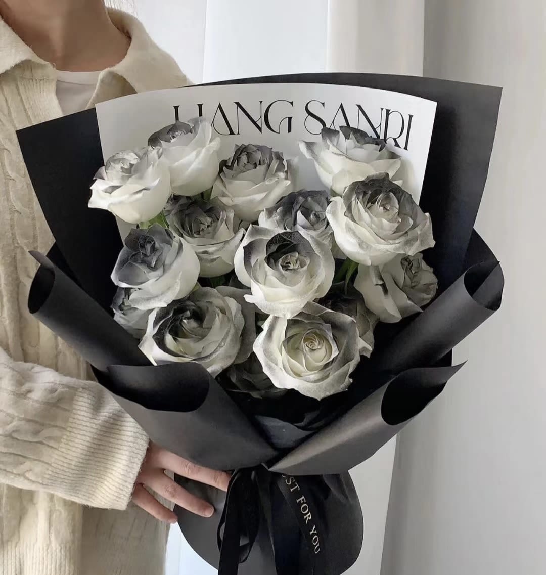 Bouquet of white roses wrapped in black paper