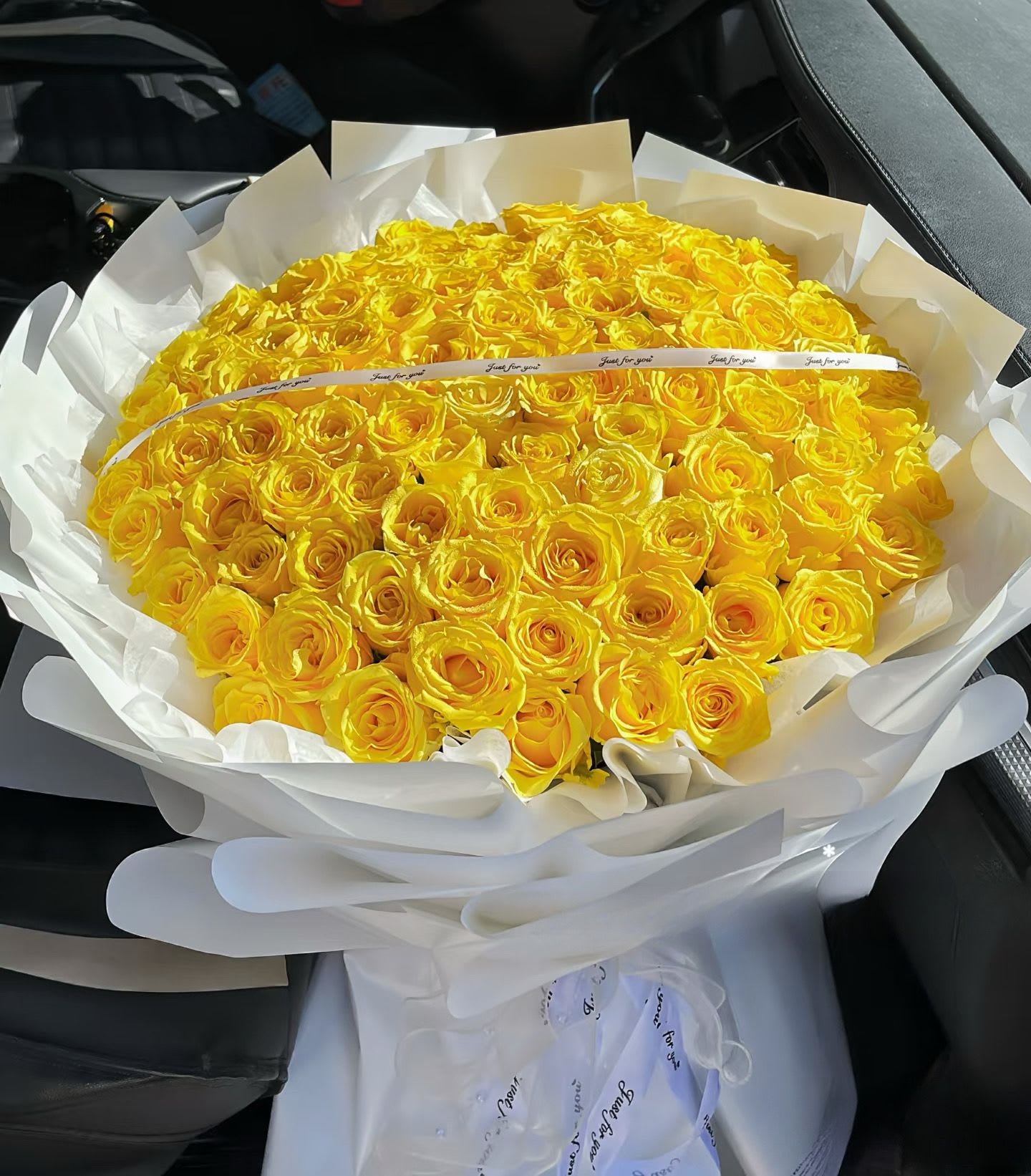 Large bouquet of yellow roses wrapped in white paper