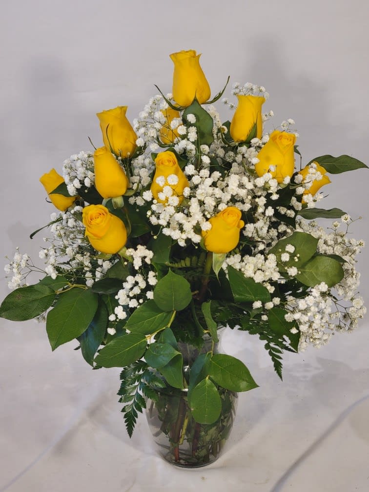 Yellow roses and baby's breath in a clear glass vase