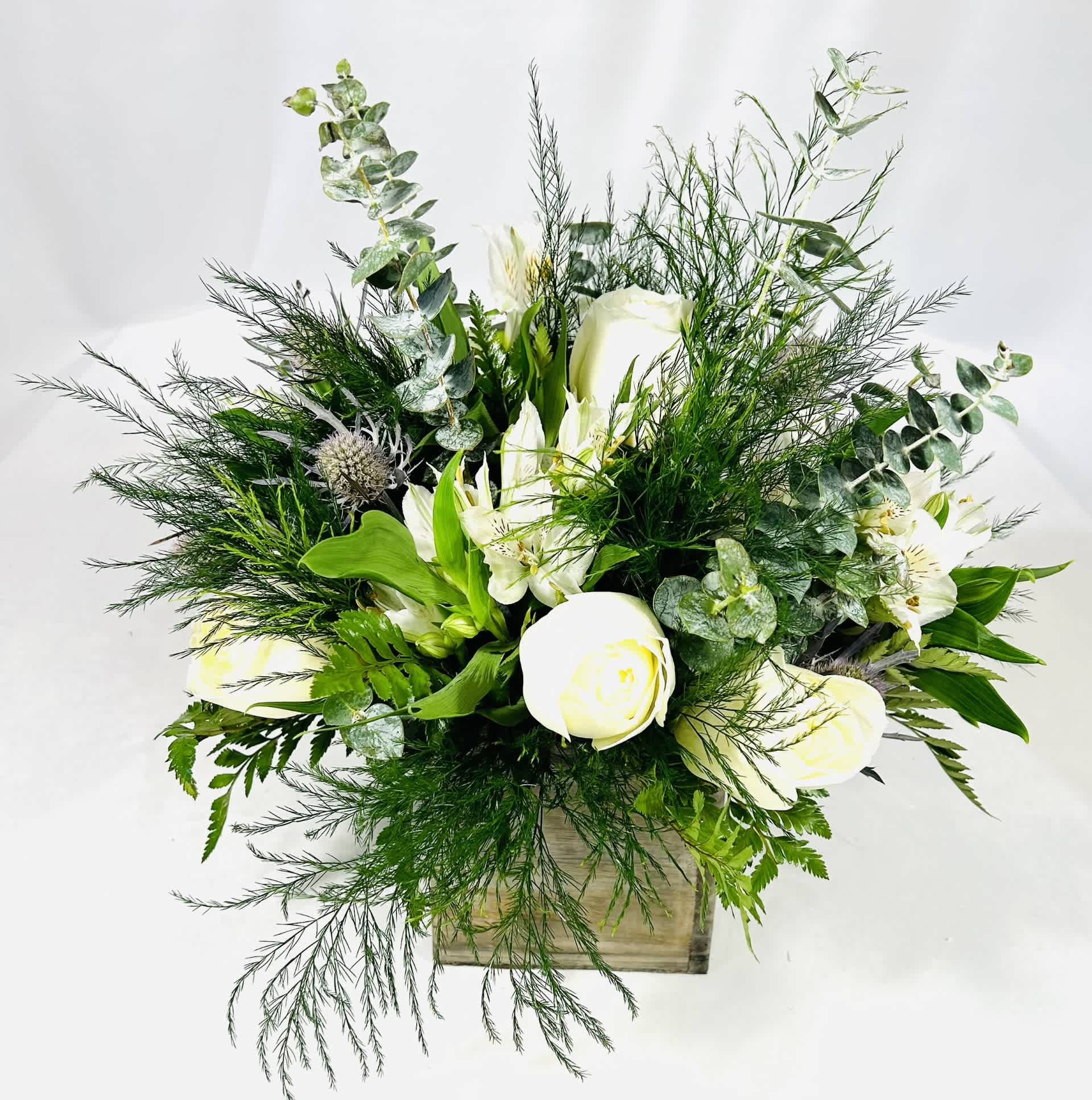 A New Day - Complementing the arrangement is our wooden cube with a all-around arrangement with white roses, blue thistle, tree fern, alstroemeria and accented with silver dollar eucalyptus and assorted greenery. Standard : 10 x 10 Deluxe : 10 x 12 Premium : 10 x 14