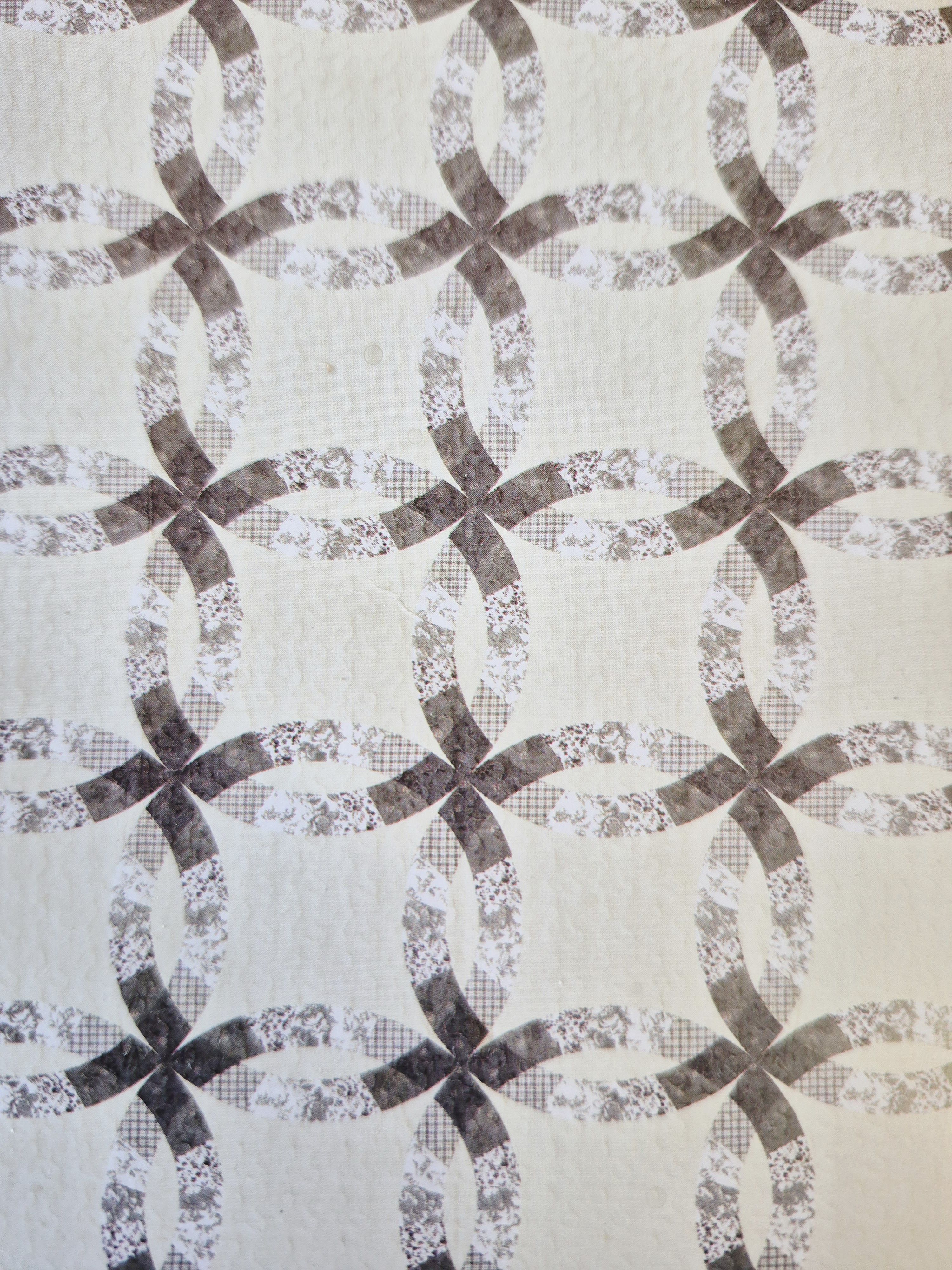 Patterned fabric with interlocking oval and bow shapes in muted brown and gray