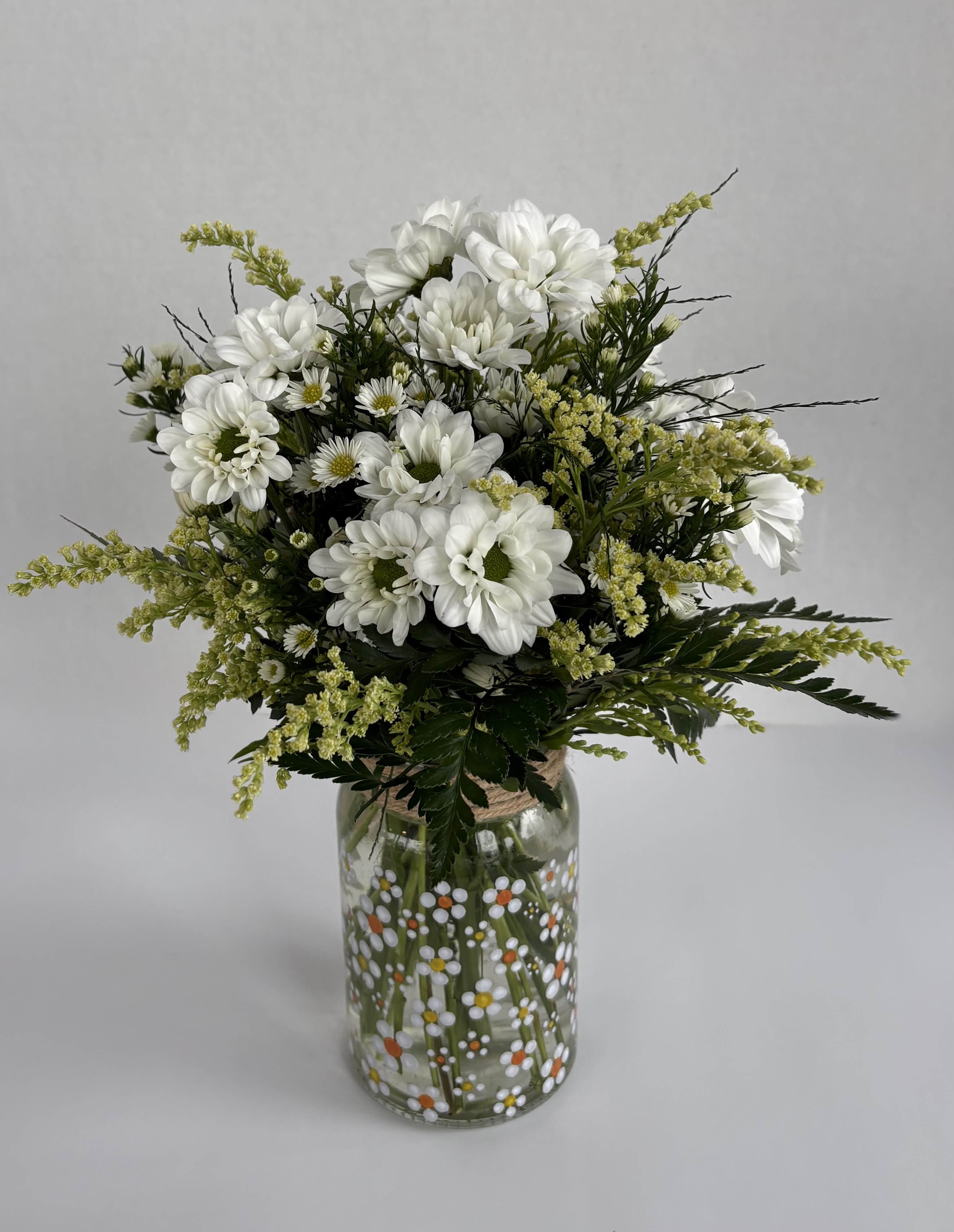 Daisy Fields - Daisy Fields is a sweet little arrangement made of white daisies and white asters designed in a clear mason jar with little white daisies all over. Spread joy through daisies!