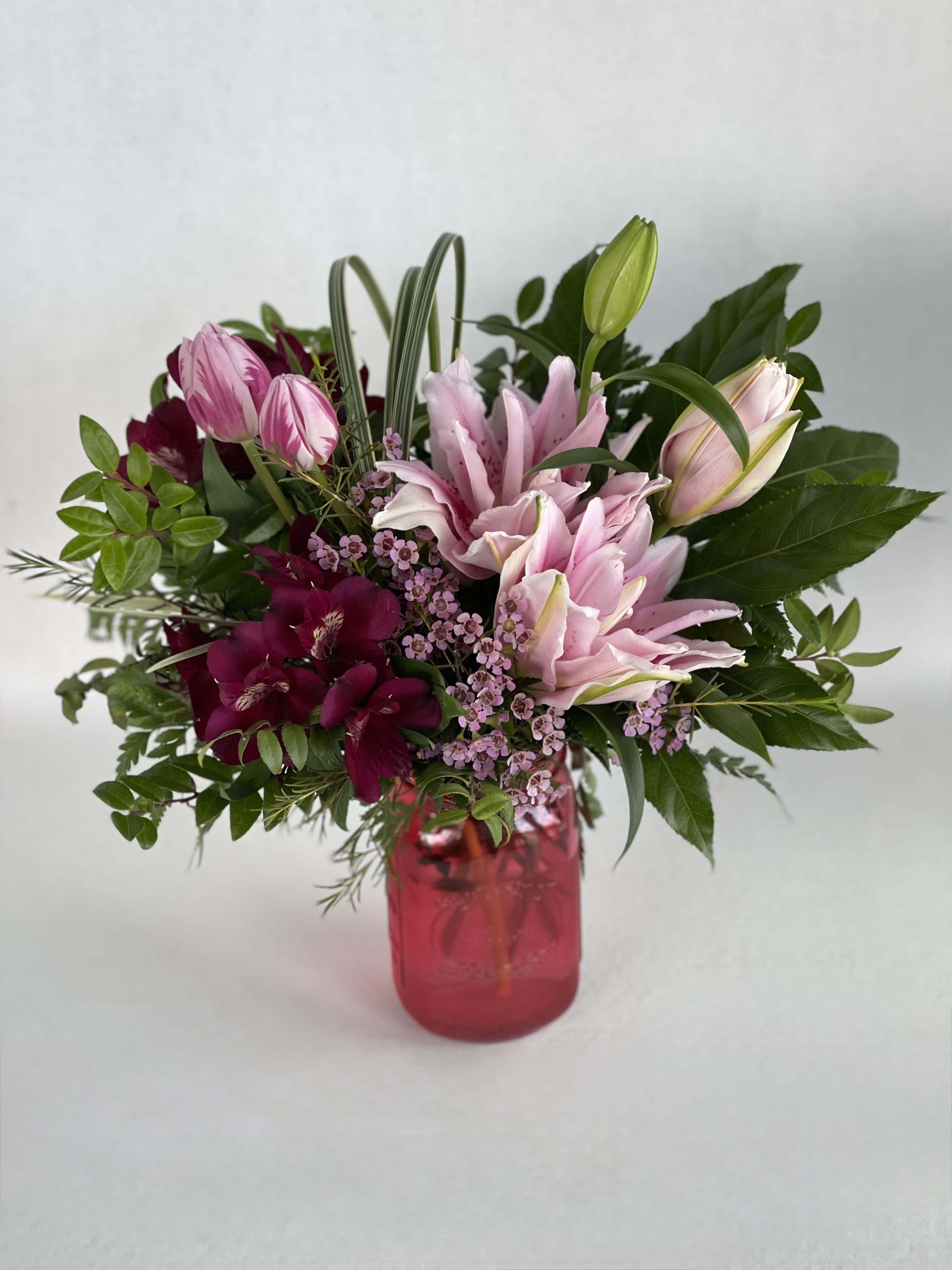 Magenta Meringue - These pops of pink are a great gift for any occasion. With pink rose lily, magenta alstromeiria, pink tulips and a variety of luxe greens, this design is sure to gain lots of attention. Bring the gift of light and airy flowers to someone in your life today!