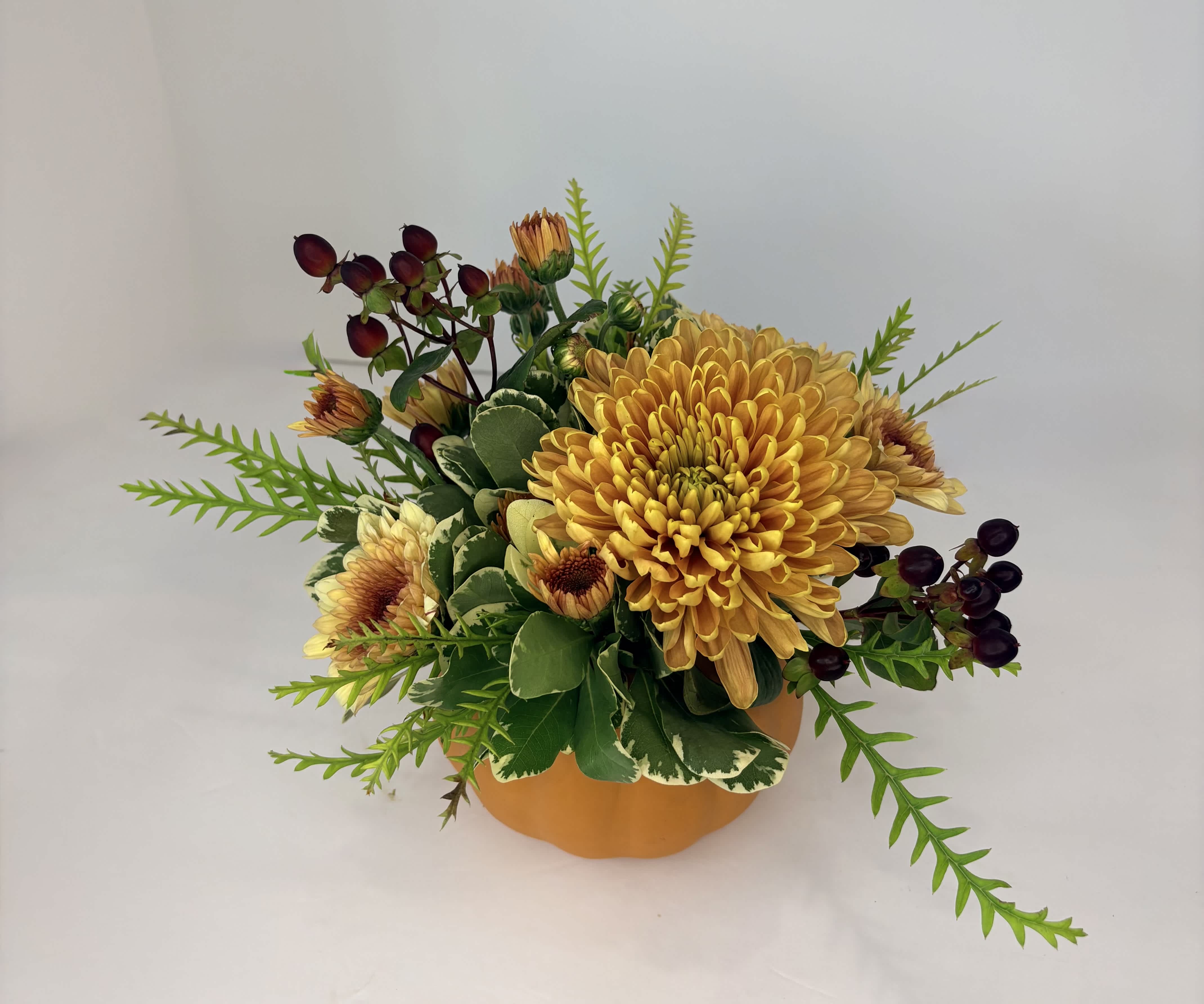 Yellow chrysanthemum arrangement in a round orange container