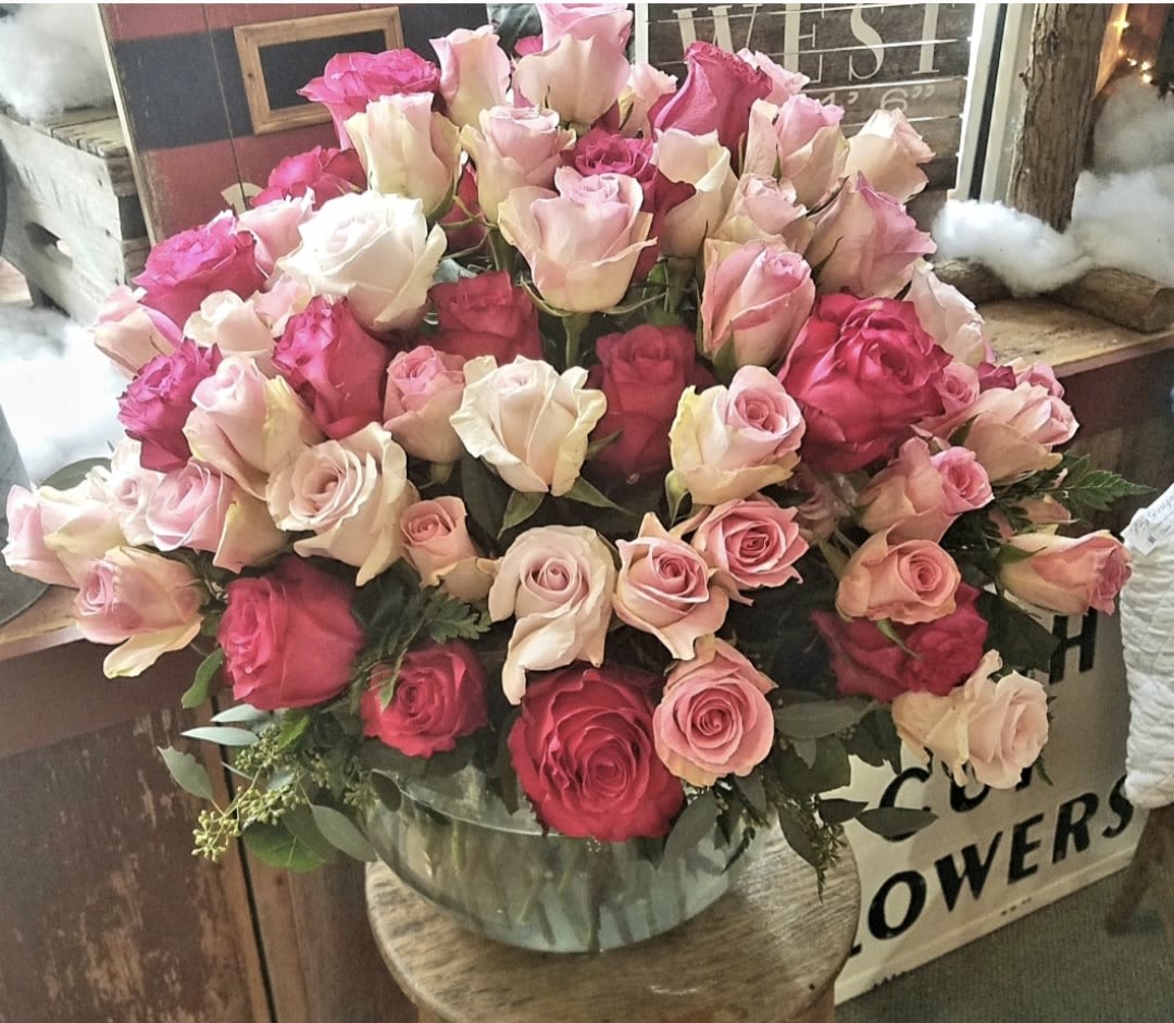 Large bouquet of pink and cream roses in a clear vase