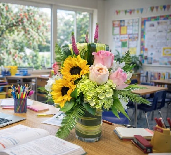 Bouquet of sunflowers and pink roses in a glass vase
