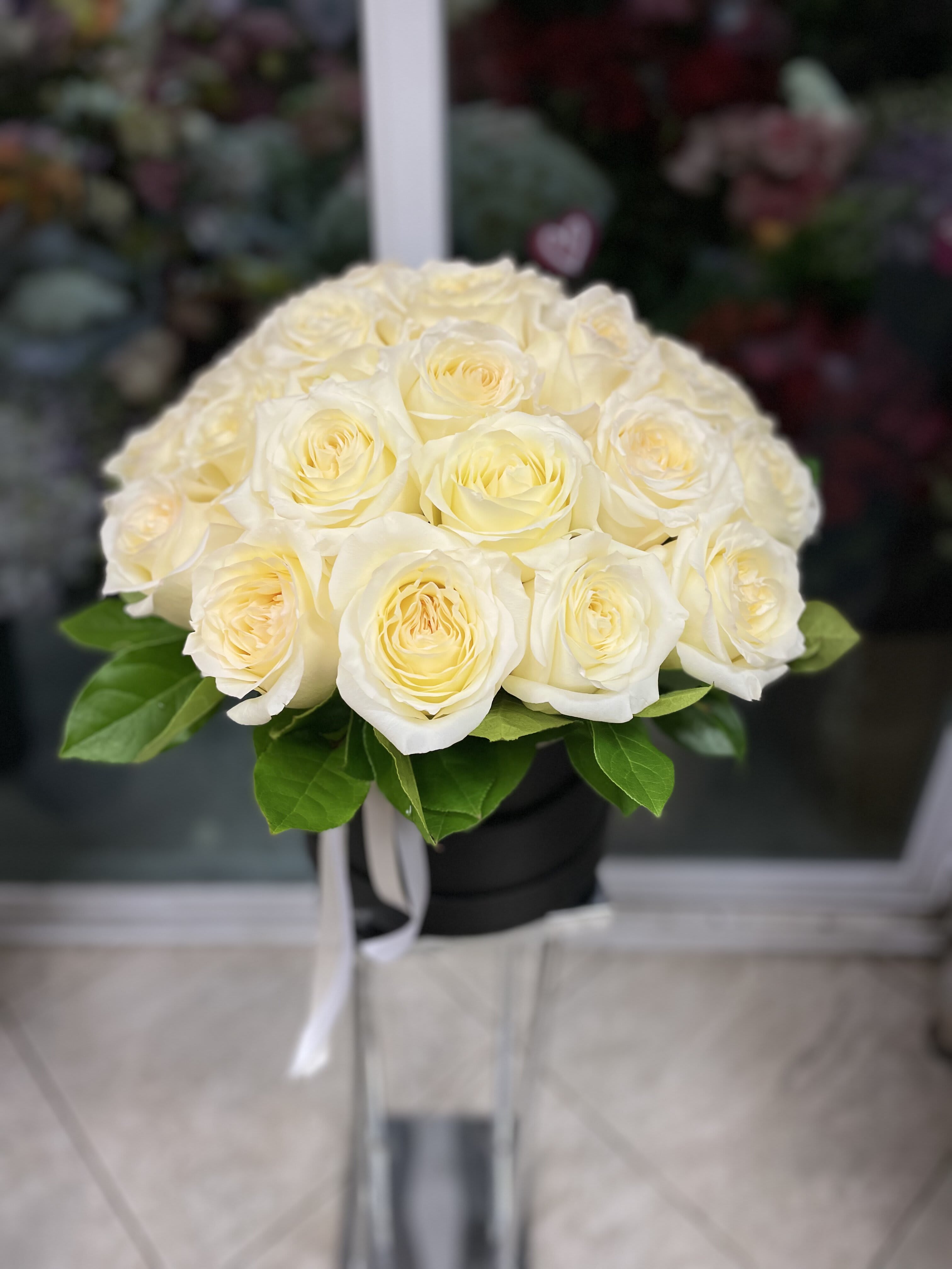 Bouquet of cream white roses in a black box with a white ribbon
