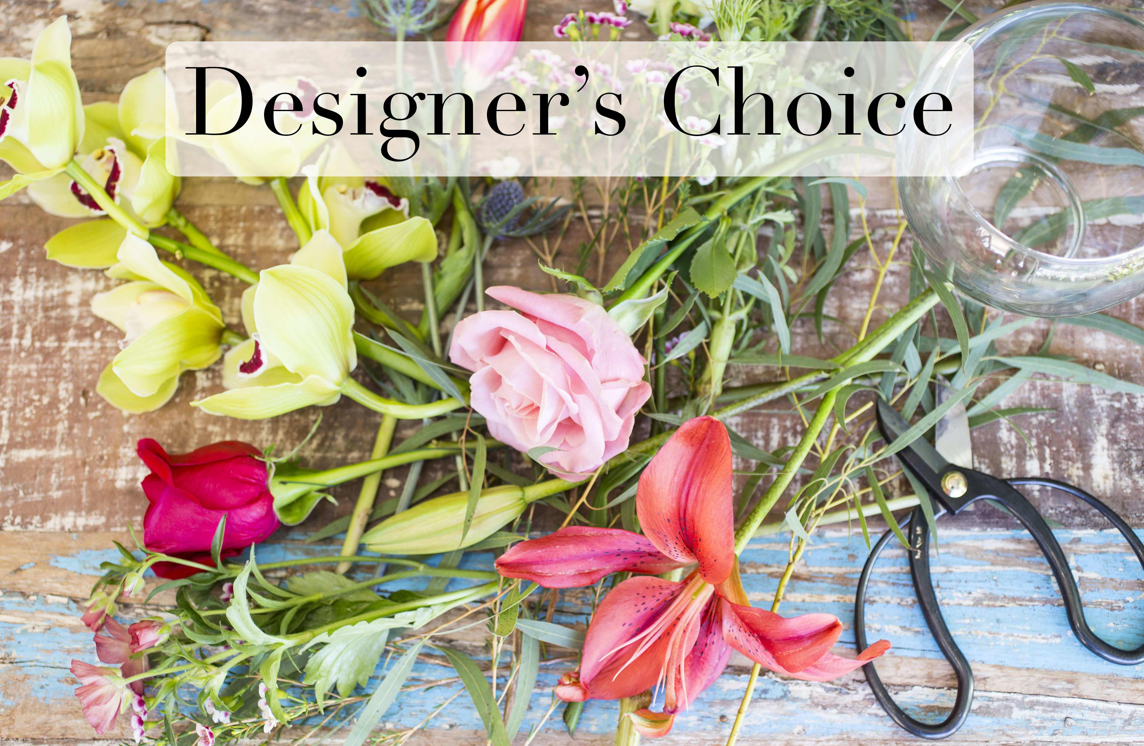 Assorted flowers and stems laid out with scissors and a glass bowl