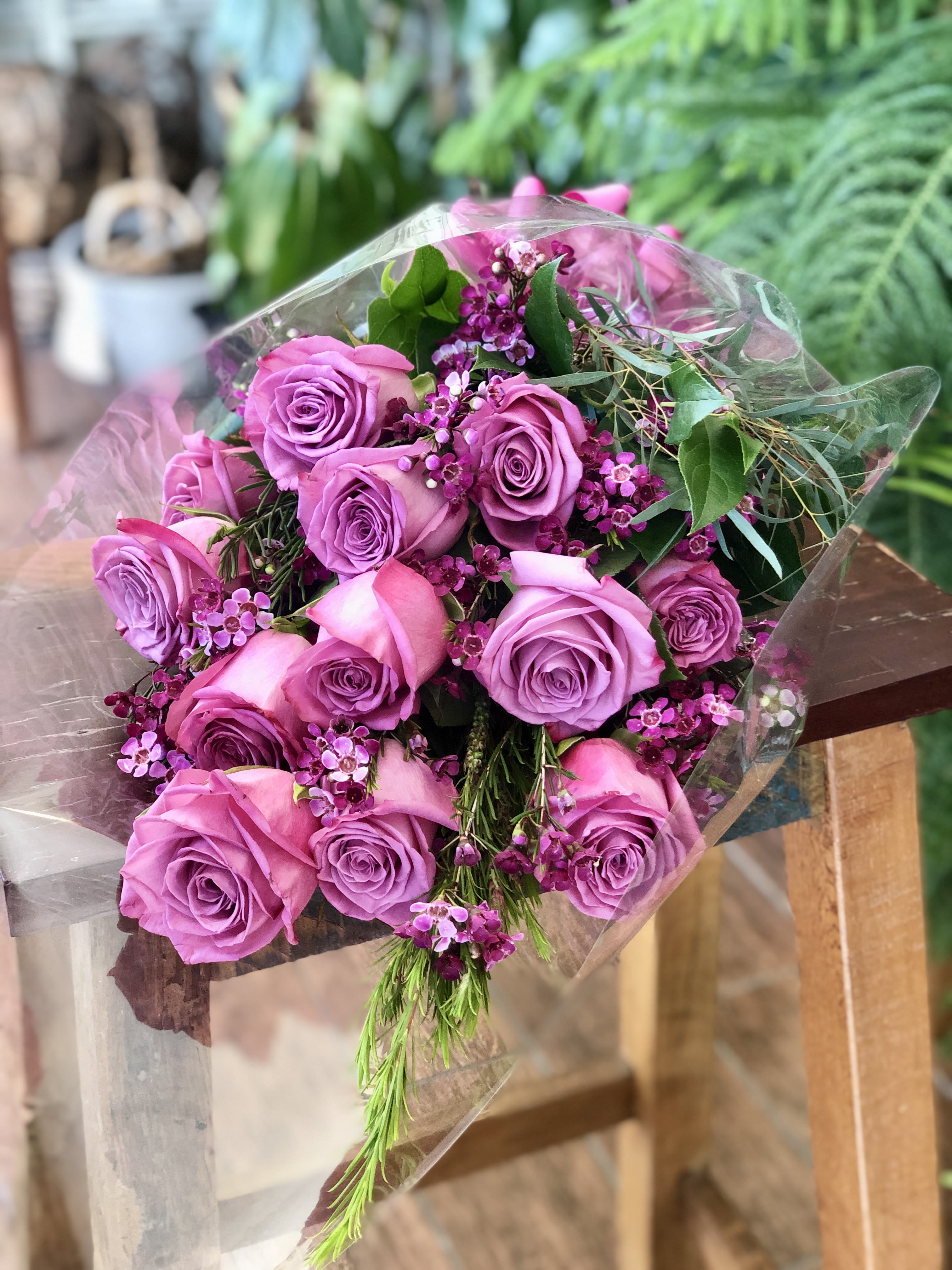 Bouquet of lavender and pink roses wrapped in clear plastic