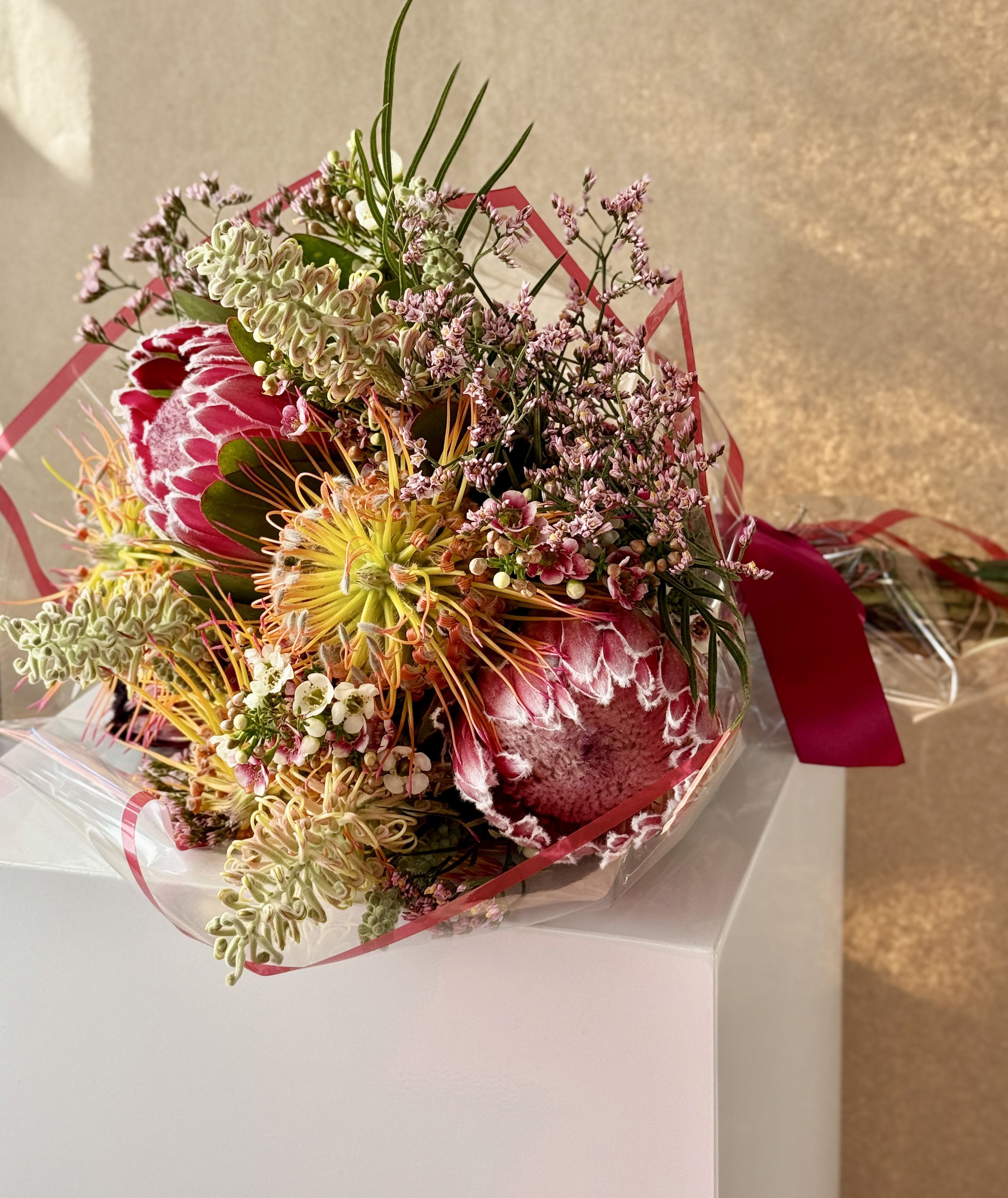 Aurora - Exotic bouquet with protea and grevillea with seasonal accents.
