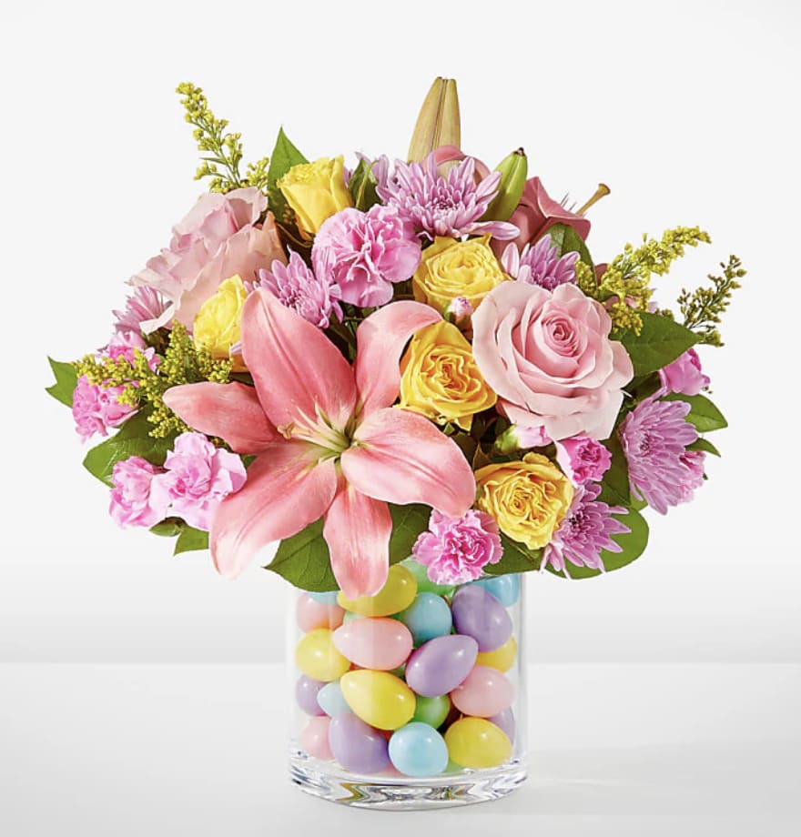 Easter Time - This joyful explosion of pink, lavender and yellow is sure to light up their table this spring! Details The Deluxe Bouquet is approximately 14"H x 16"W. 