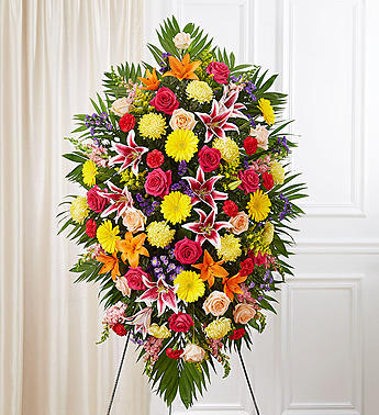 Large standing spray of mixed flowers in bright colors on an easel