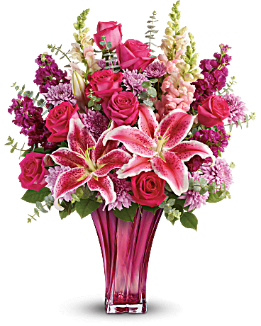 Pink roses and lilies in a tall glass vase