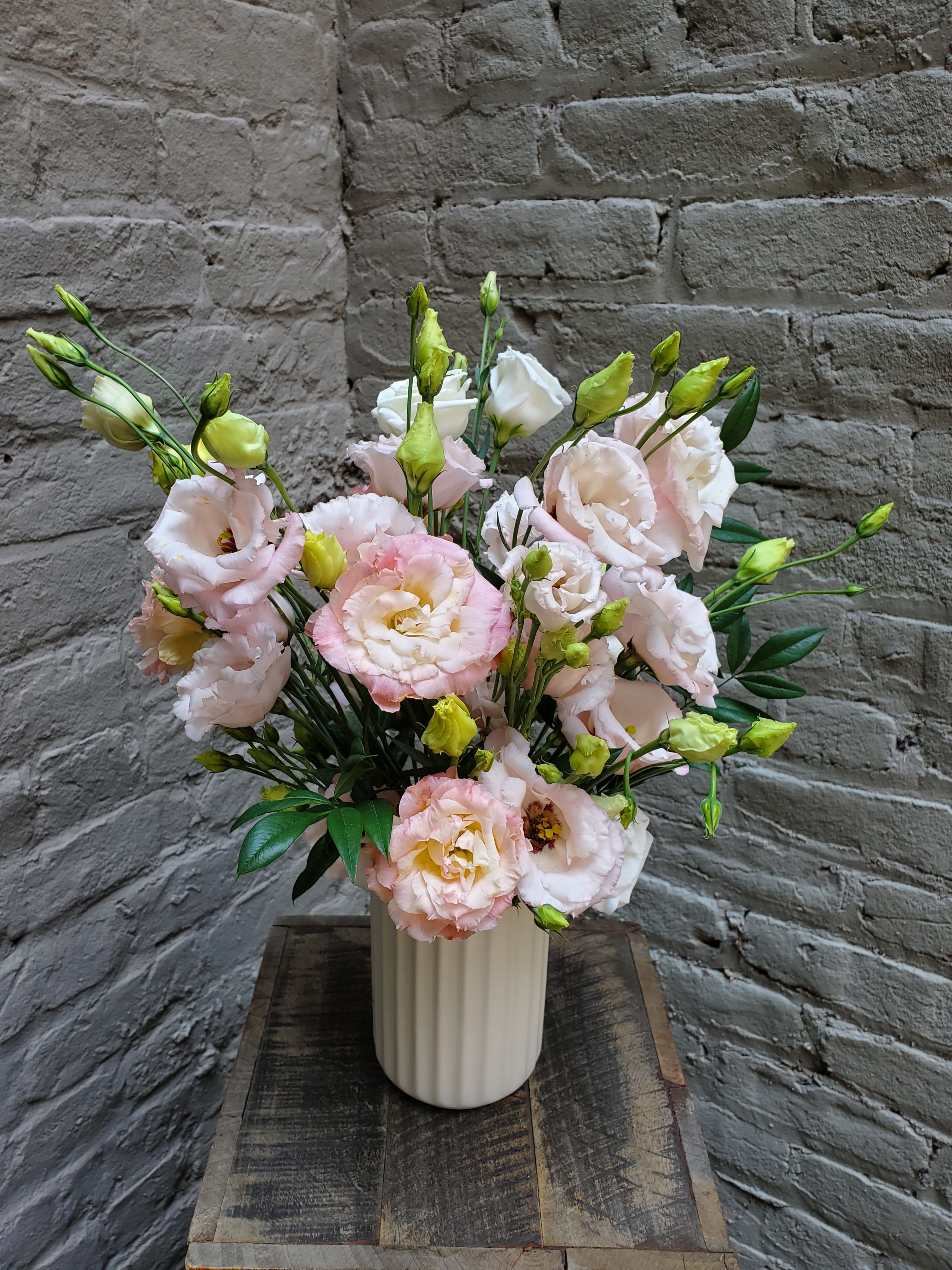 Soft Serenade - A beautiful collection of locally-grown lisianthus in a simple white ceramic vase.  Standard measures approximately 16" tall by 10" wide.