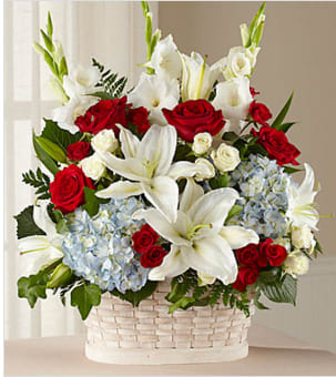 The FTD Greater Glory Basket - Celebrate the life of a departed friend or family member with an exuberant and patriotic bouquet of red, white and blue flowers. Comforting memories of a life lived in service to the country are bought to mind with red and white roses, white gladioli and Oriental lilies, and blue hydrangeas beautifully arranged in a simply lovely white woodchip basket. Perfect for floor or tabletop display at any occasion.  GOOD arrangement includes 23 stems. Approximately 25"H x 19"W.   BETTER arrangement includes 27 stems. Approximately 27"H x 19"W.   BEST arrangement includes 32 stems. Approximately 27"H x 21"W. 