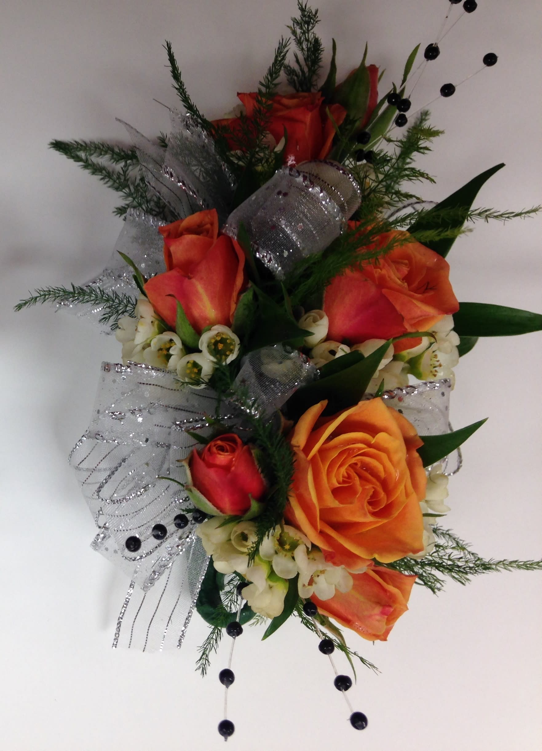 Spray Rose Corsage - Spray Rose Corsage with assorted greens and filler. Colors and ribbons may vary. When ordering please specify color of dress, color of roses preferred and color of ribbon preferred in order notes. Please include 2nd choice for rose color and ribbon colors. We will call you by phone if preferred ribbon color is unavailable.