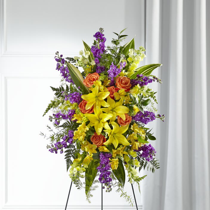 Thoughtful Prayers Standing Spray - Our Thoughtful Prayers Standing Spray beautifully remembers their passion and radiance within each bright bloom. Bold lilies, roses, stock and snapdragons are paired with lush greens to celebrate the life of a loved one. 