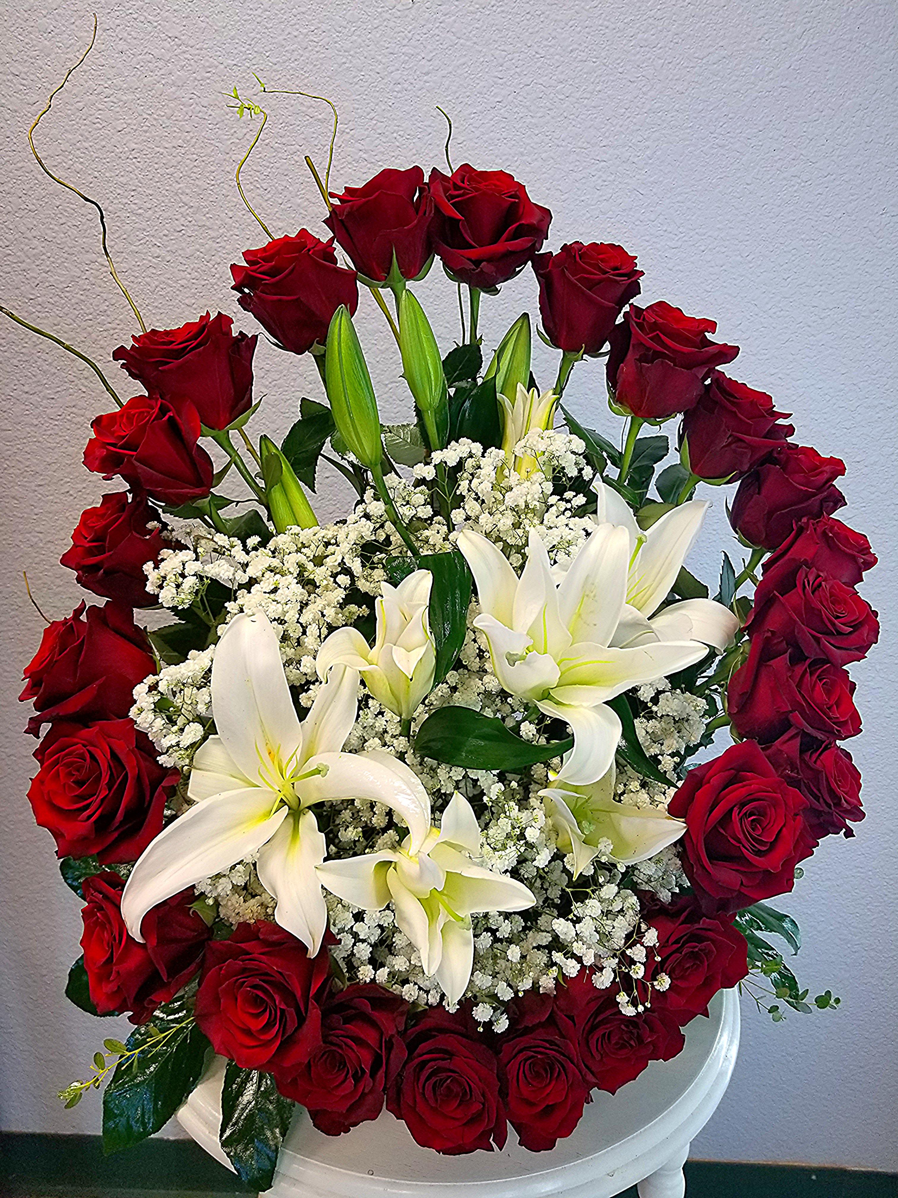 Red roses and white lilies arranged in a white vase