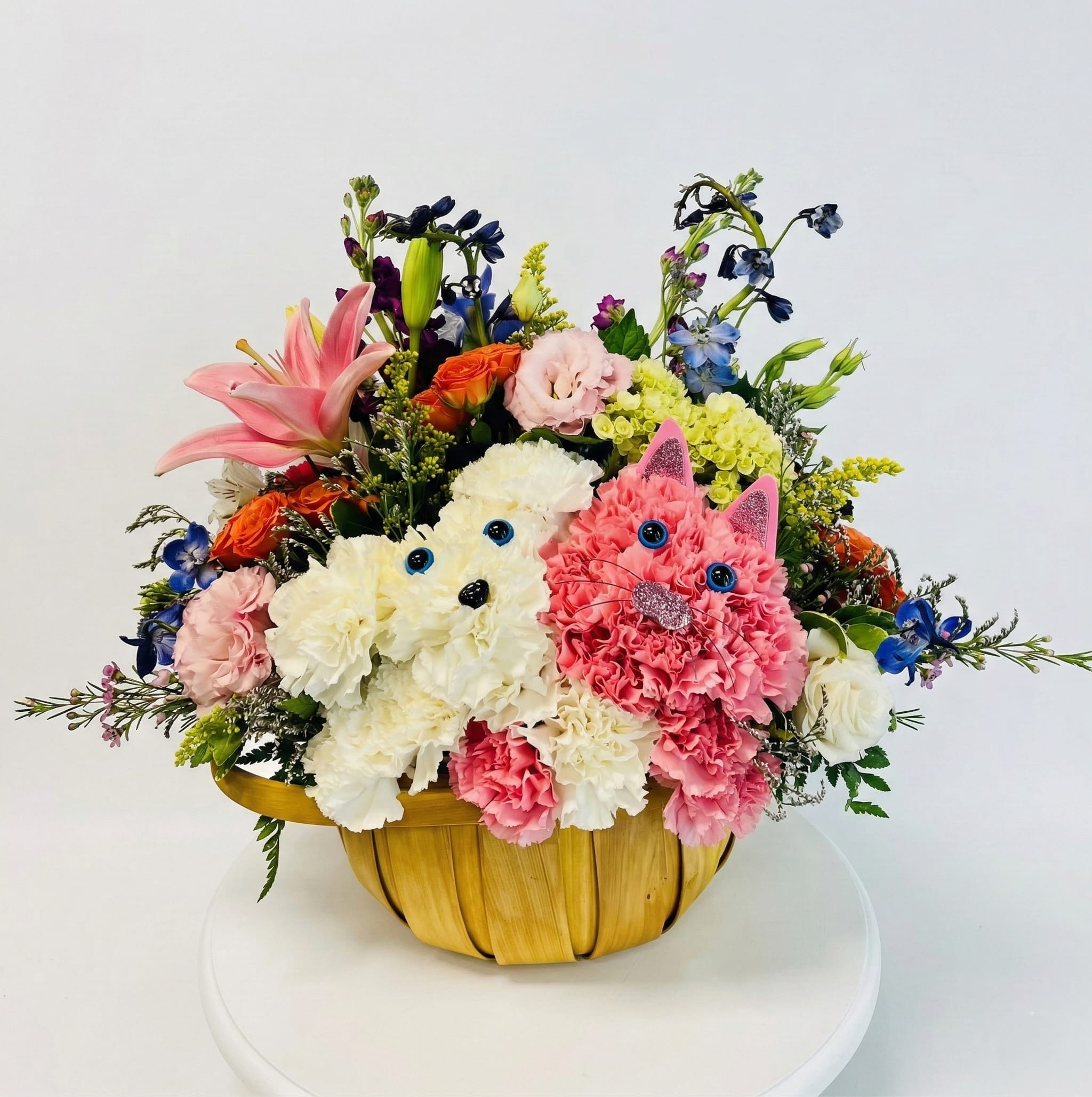 Colorful flower arrangement in a woven basket with two cat faces