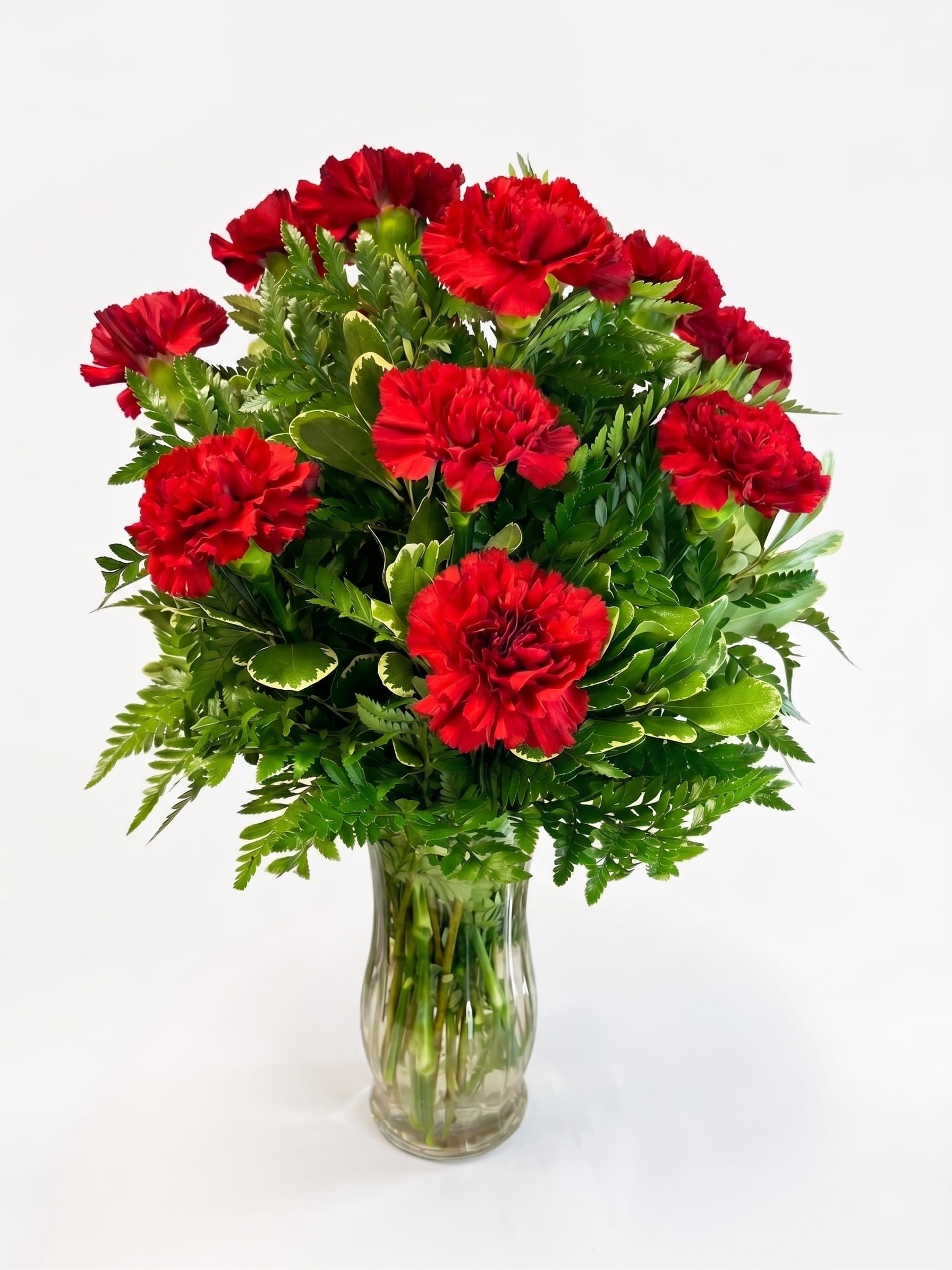 Red carnations arranged in a clear glass vase