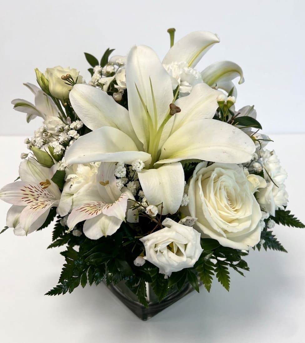 Timeless Elegance Bouquet - Our all white Timeless Elegance Bouquet in a clear glass cube is perfect for any occasion. White flowers have a timelessness and elegance that's perfect for any occasion. Hand-gathered by our caring florists with touches of lush greenery.