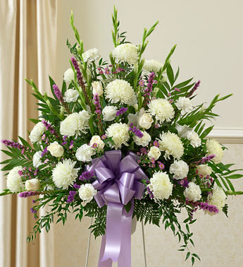 White and purple floral standing spray with a lavender ribbon