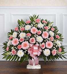 Pink and white floral arrangement in a vase with a pink ribbon bow