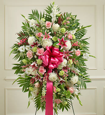 Standing floral spray with pink and white flowers and a bright pink ribbon