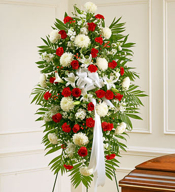 Standing floral spray with red and white flowers and a white ribbon