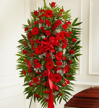 Tall red floral standing spray with a red ribbon bow